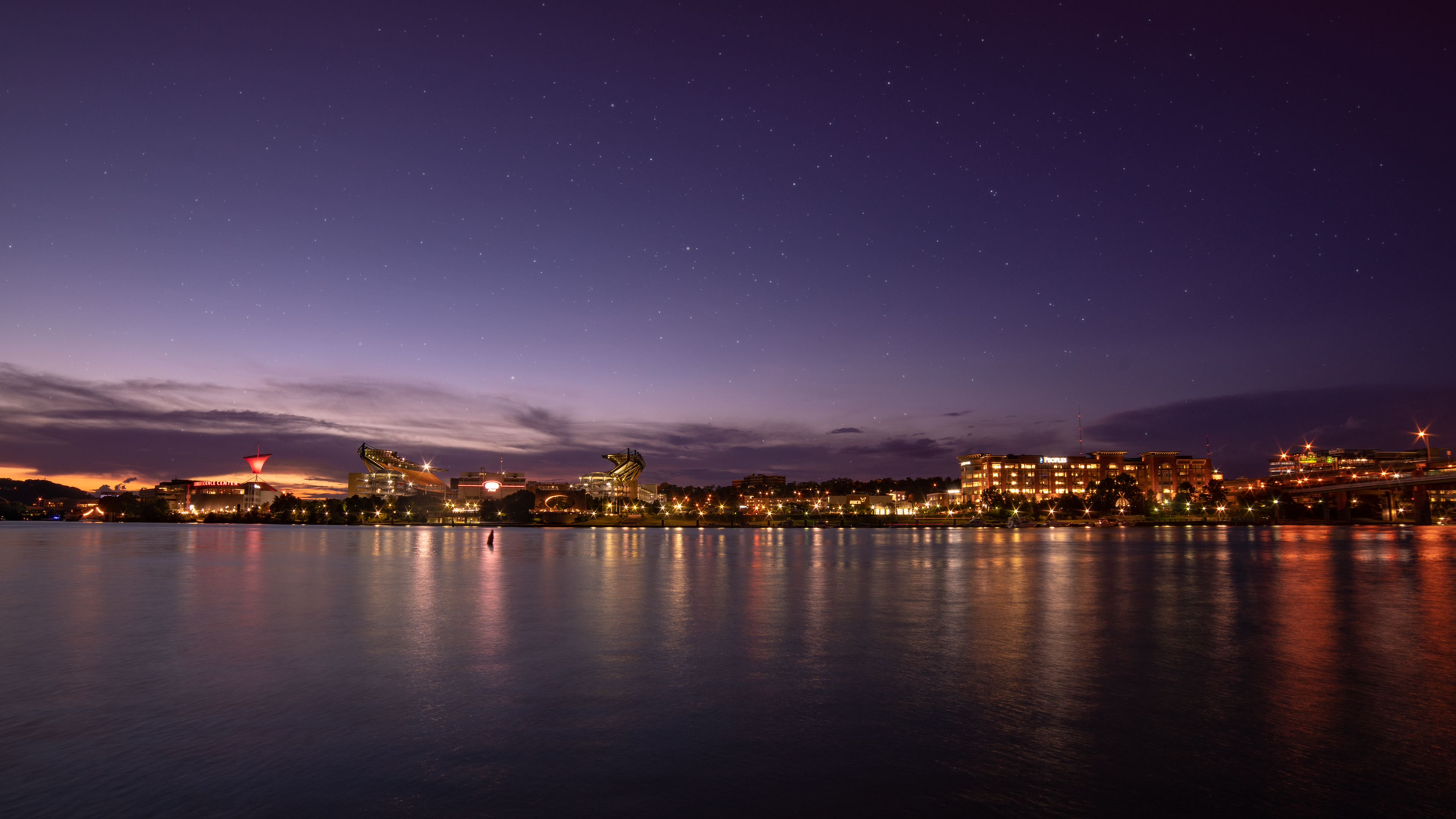 City skyline reflected in water at twilight under a starry sky, symbolizing a brand new beginning