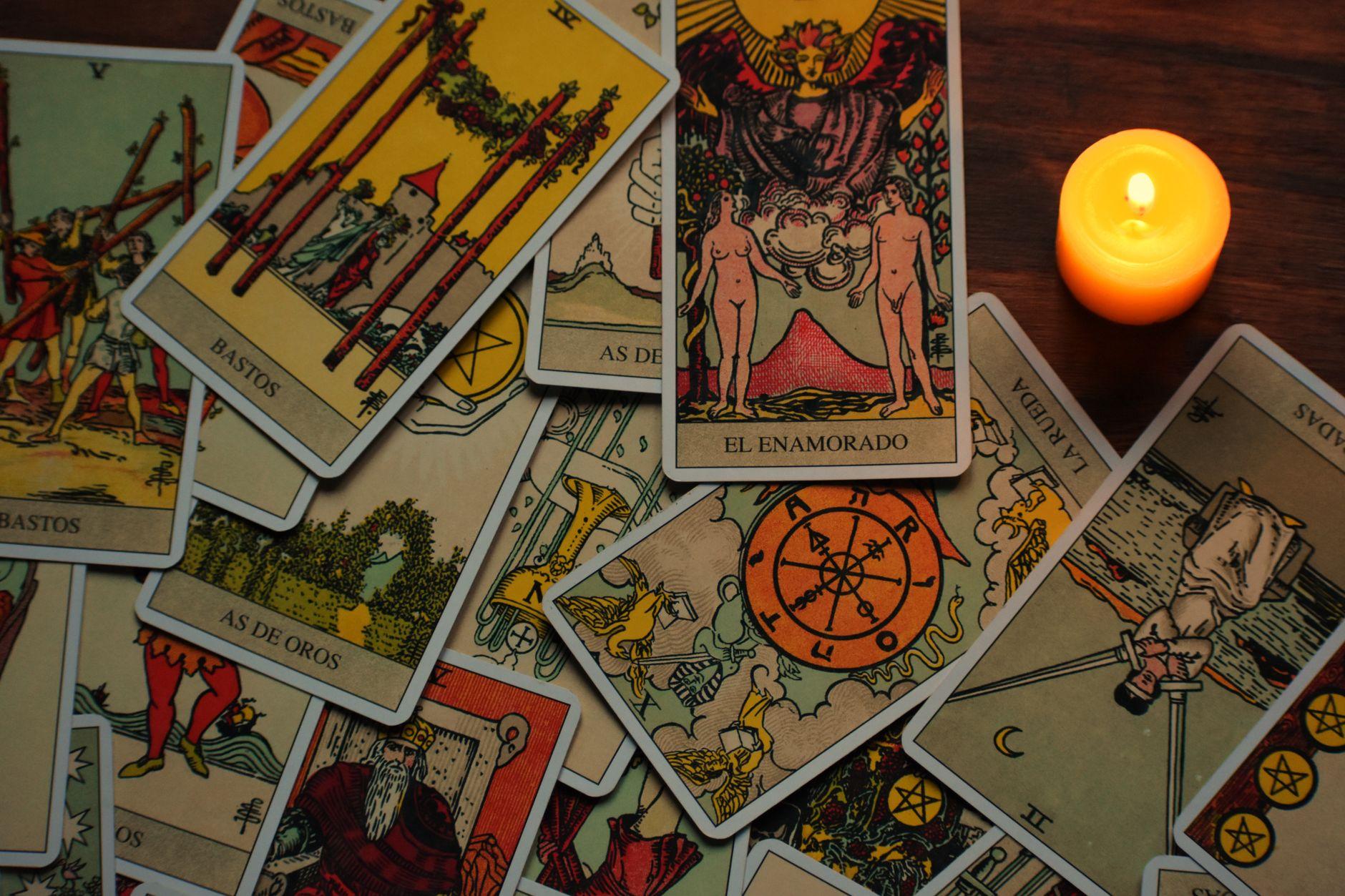 Tarot cards arranged on a table under the glow of a burning candle