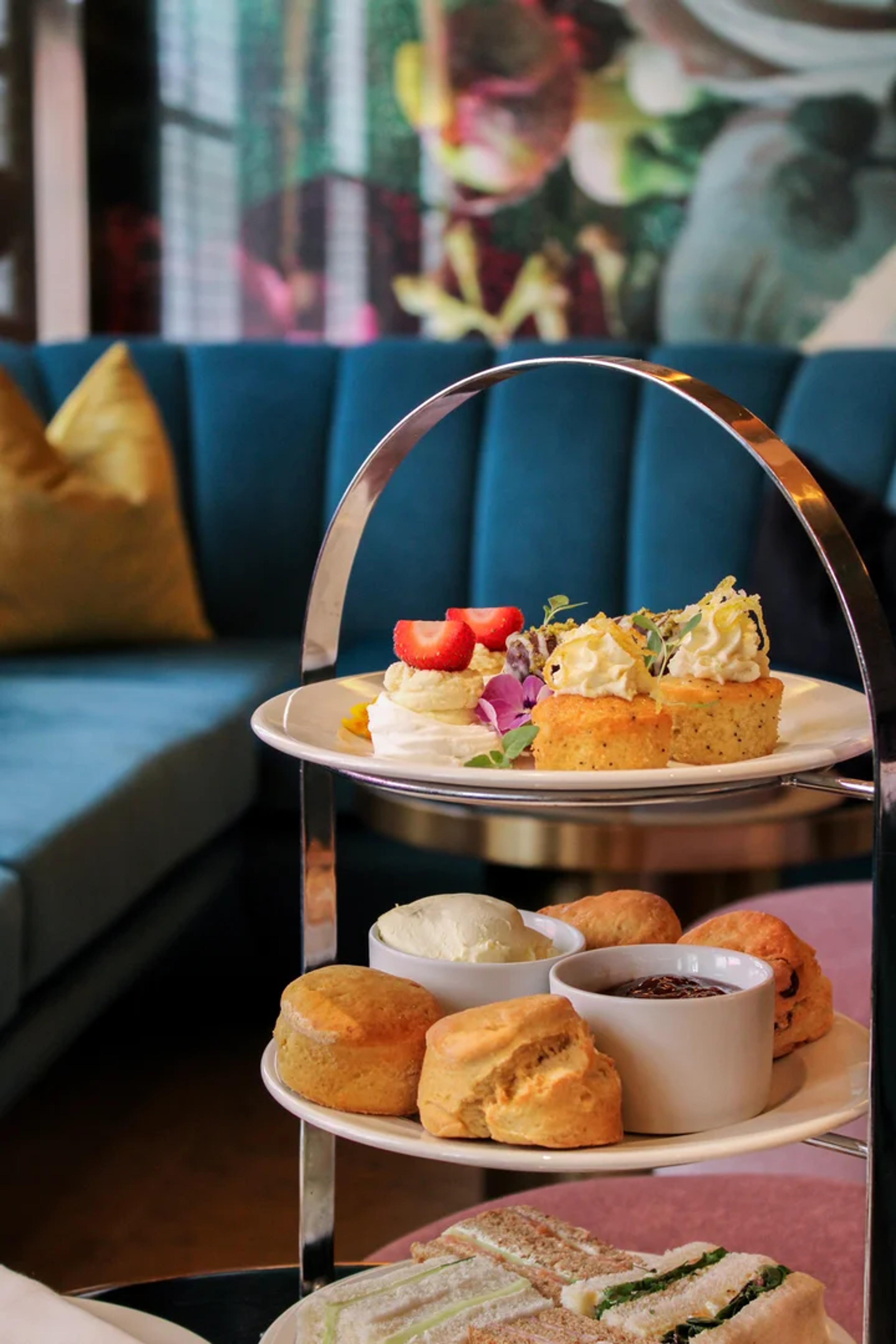 Classic three-tier afternoon tea stand with scones, sandwiches and cakes