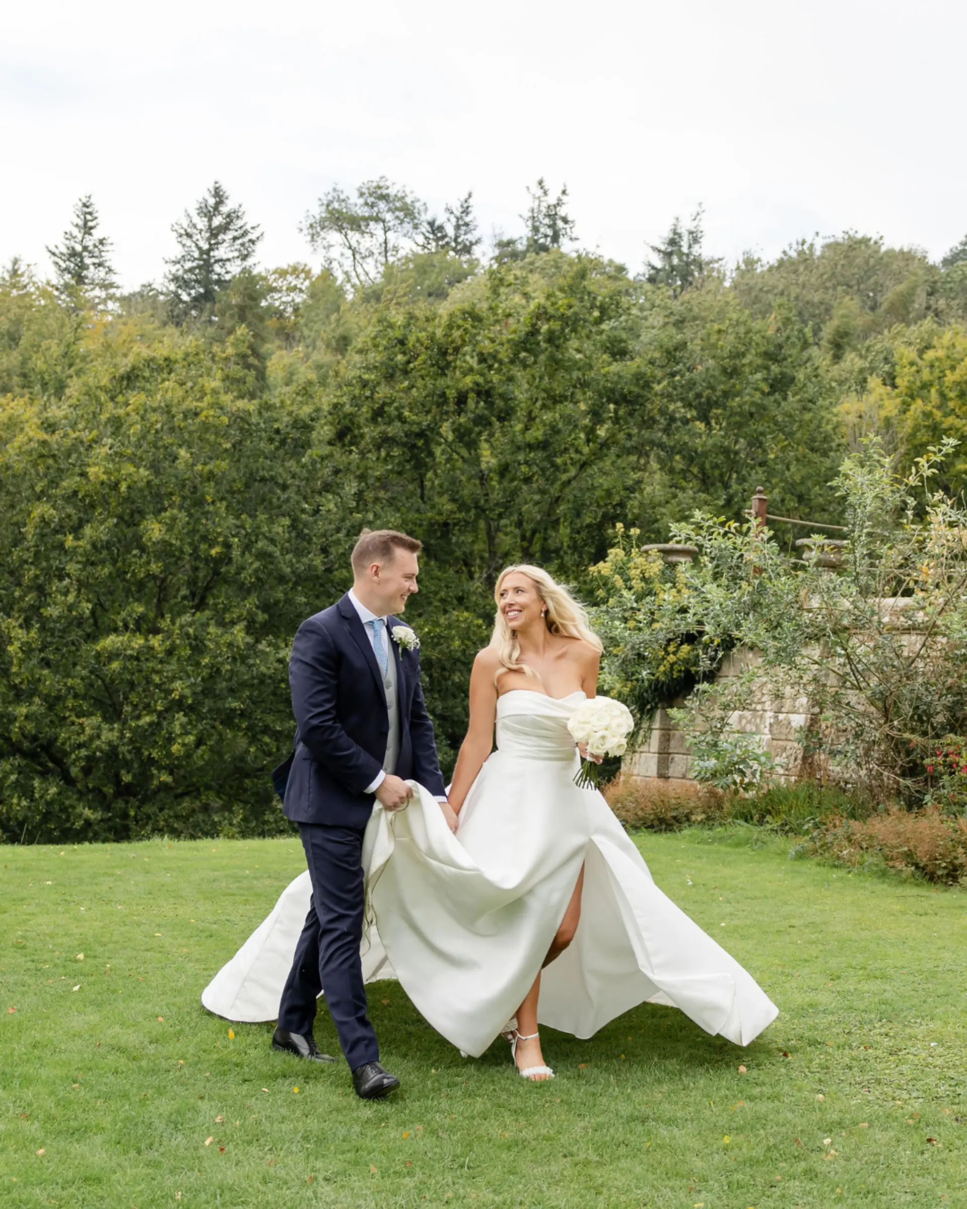 Bride and groom walking together across the lawn at Salomons Estate