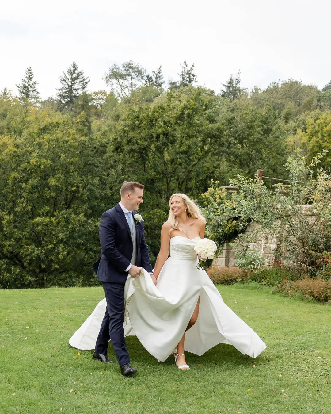 Bride and groom walking together across the lawn at Salomons Estate