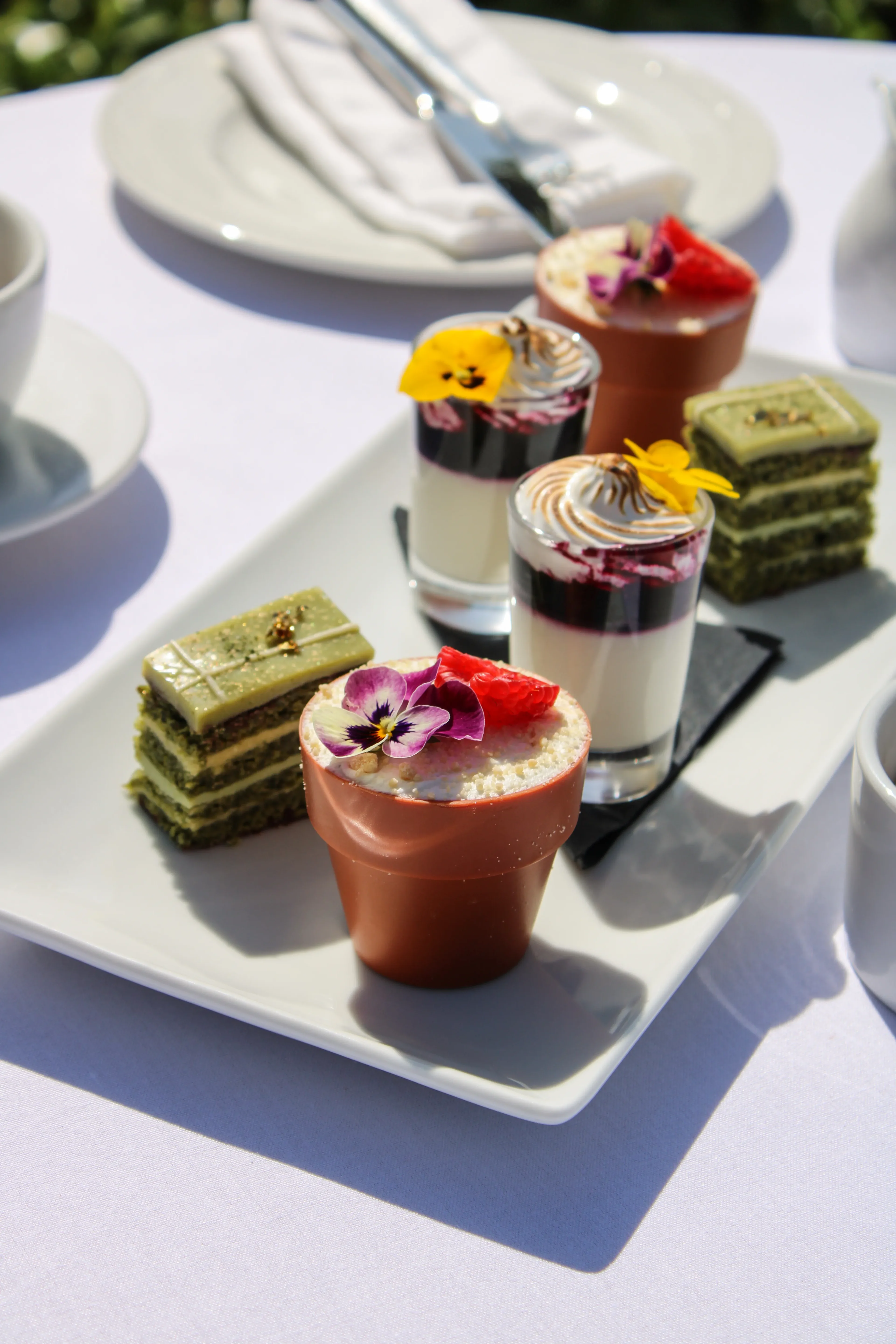 Artisan desserts with edible flowers and chocolate pots served at Salomons Estate