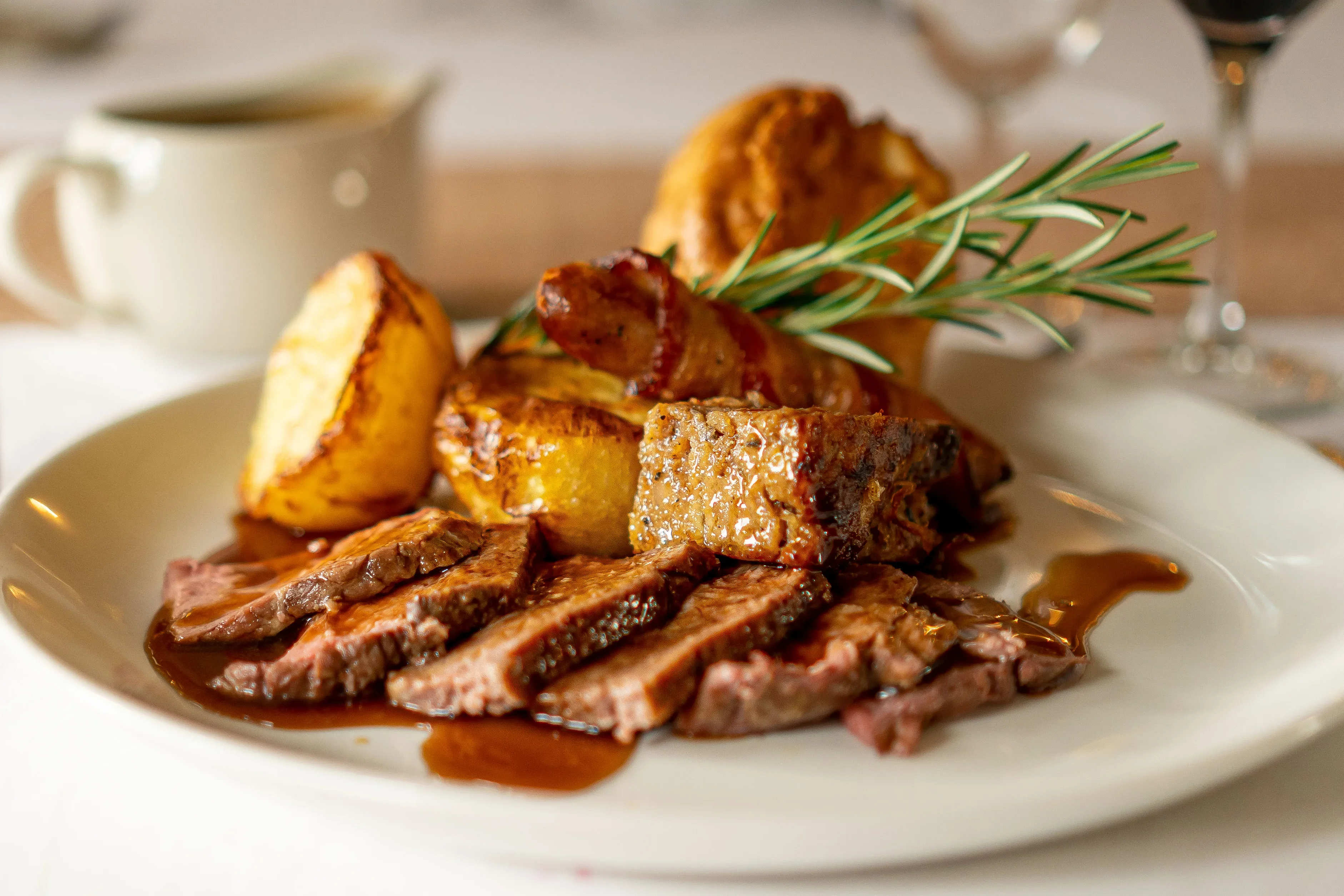 Sliced roast beef with rosemary, roast potatoes, and rich gravy at Salomons Estate