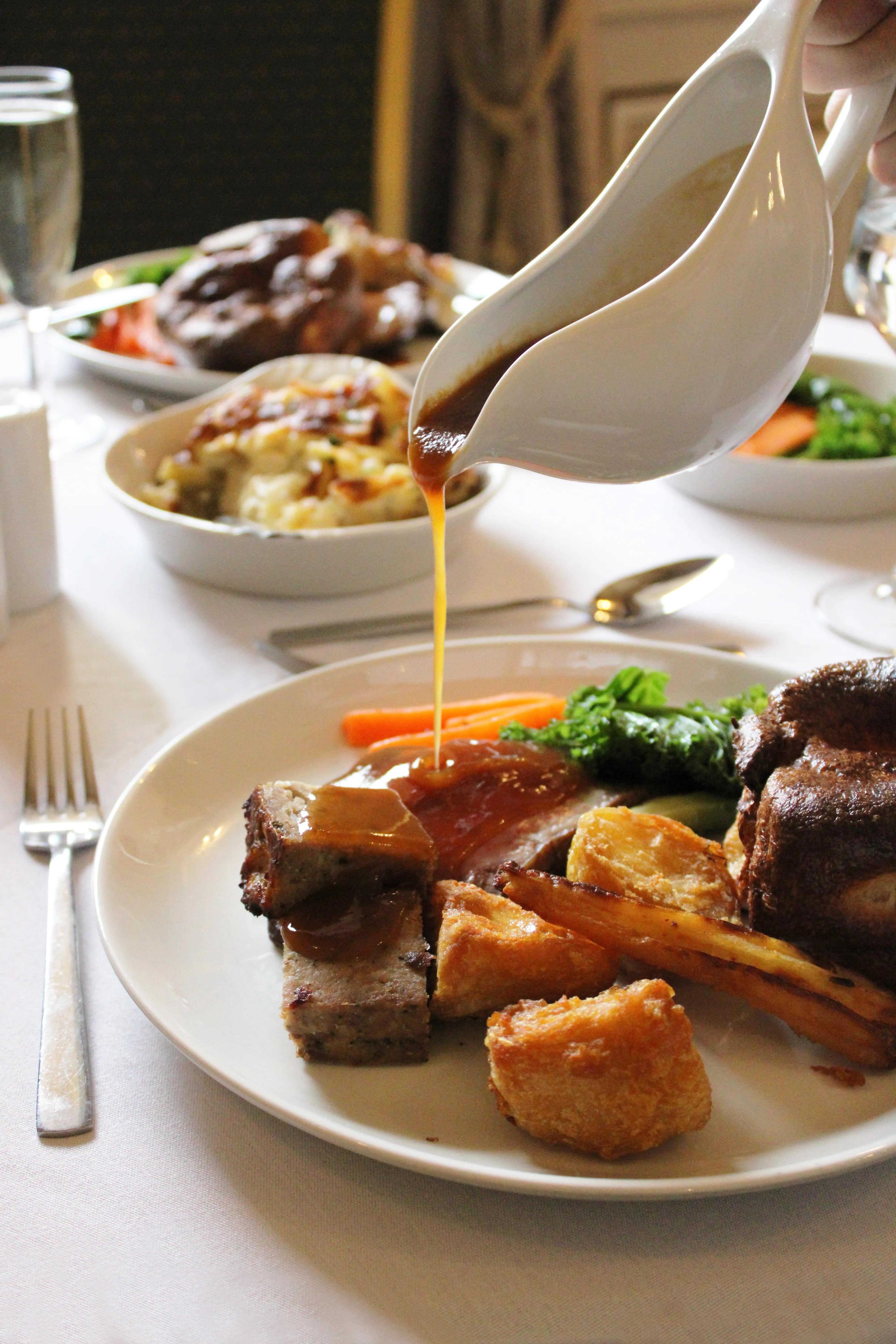 Rich gravy being poured over a traditional Sunday roast at Salomons Estate