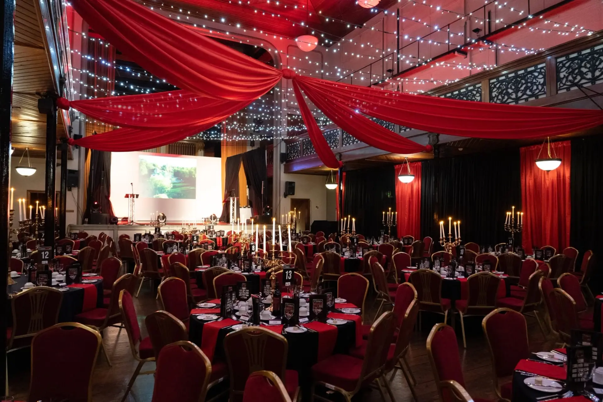 Private Christmas party with red drapes and candlelit tables at Salomons Estate