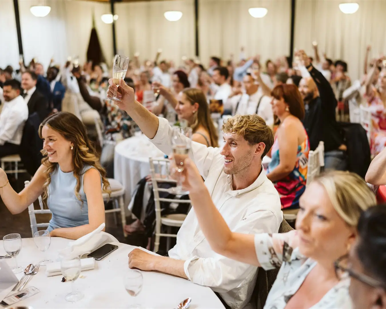 Wedding guests raising glasses during a reception at Salomons Estate