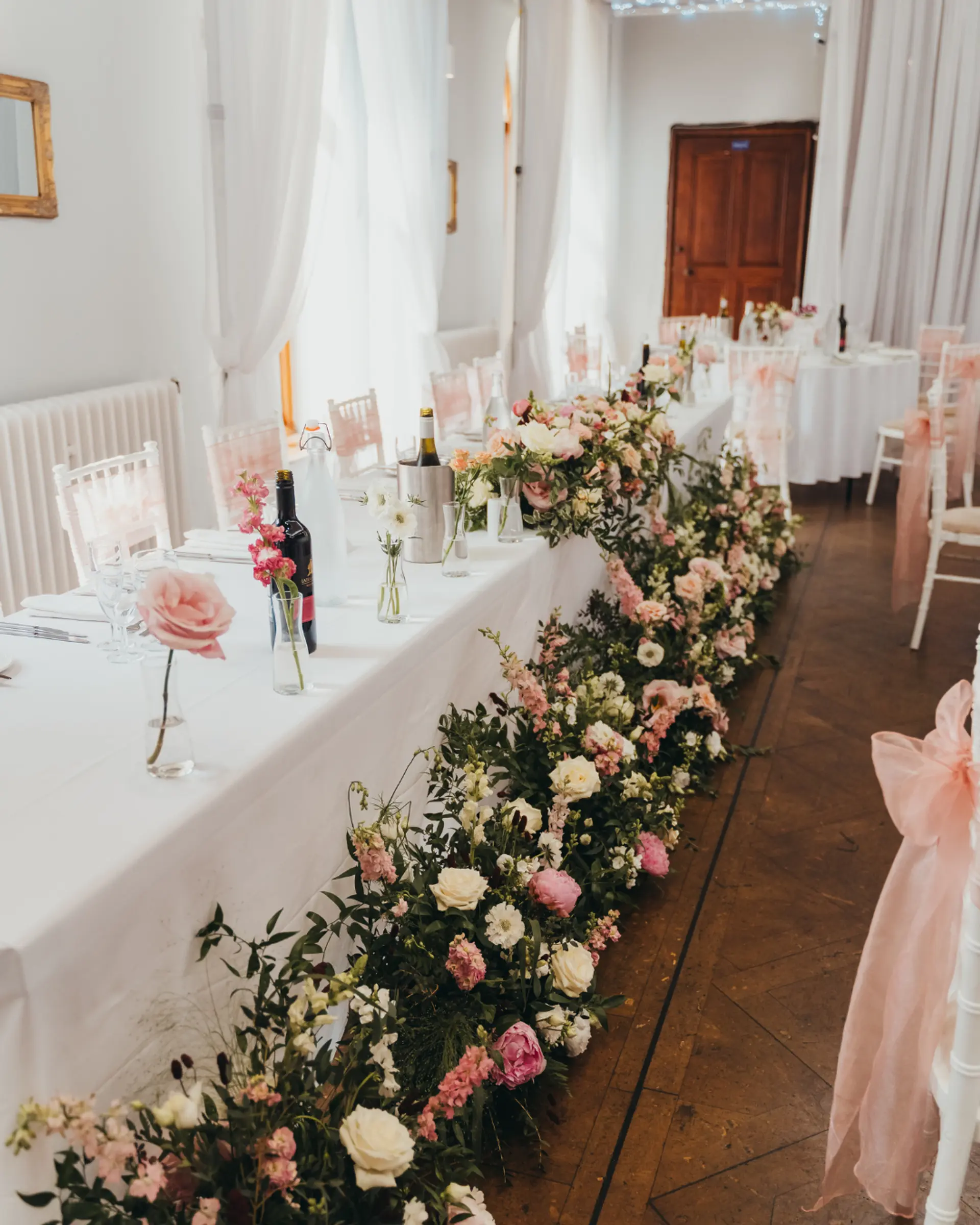 Floral wedding breakfast styling in a light-filled reception room at Salomons Estate