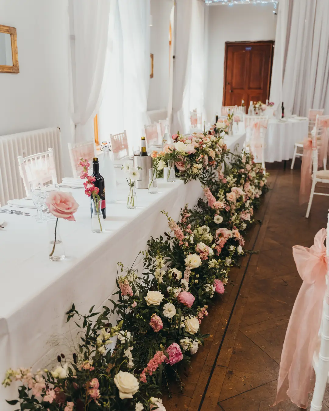 Floral wedding breakfast styling in a light-filled reception room at Salomons Estate