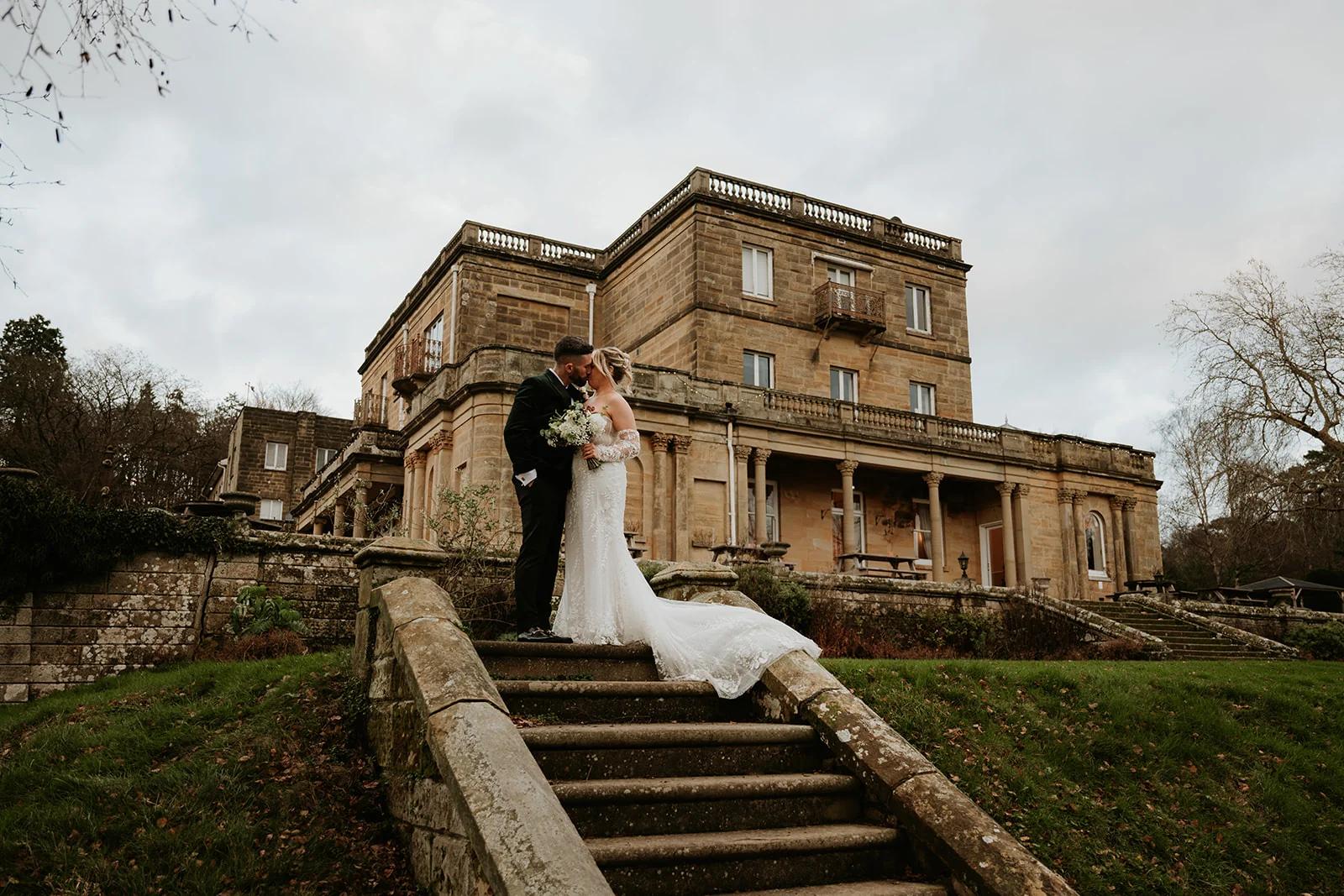 Wedding couple on the steps surrounded by autumn leaves