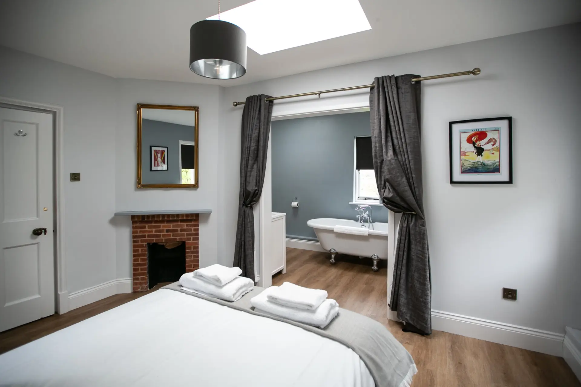Bedroom with an open doorway through to a roll top bath in The Gatehouse at Salomons Estate