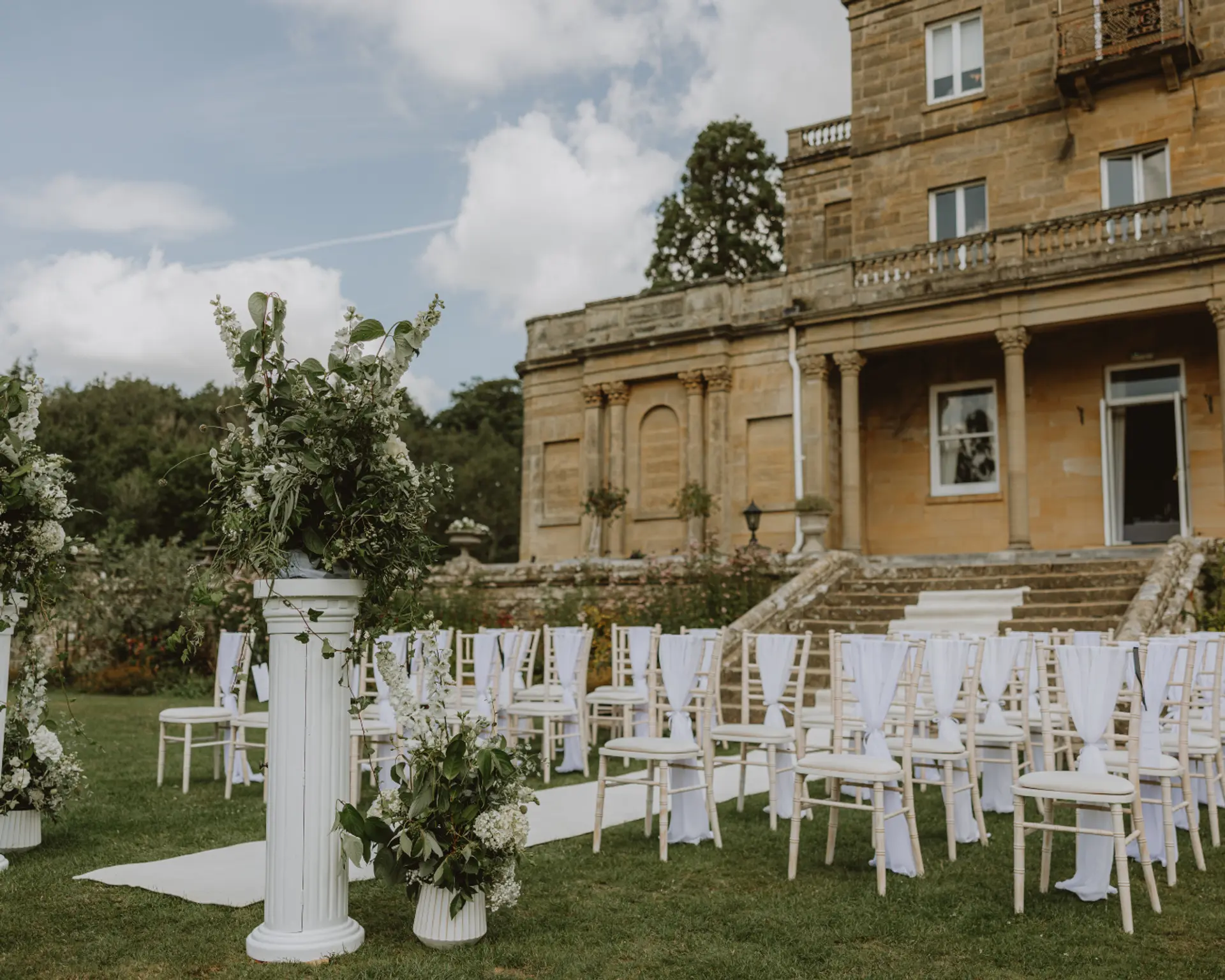 Outdoor ceremony setup with the Victorian manor house at Salomons Estate