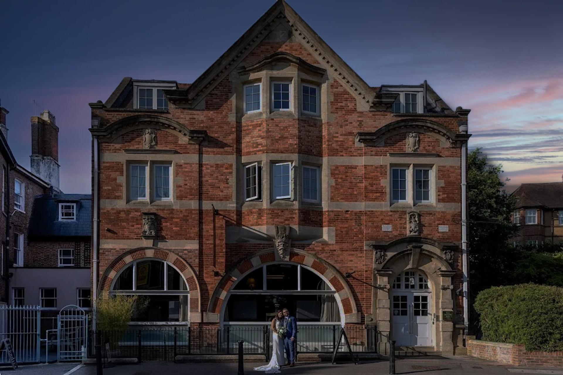 Bride and groom under the arch at dusk outside One Warwick Park Hotel