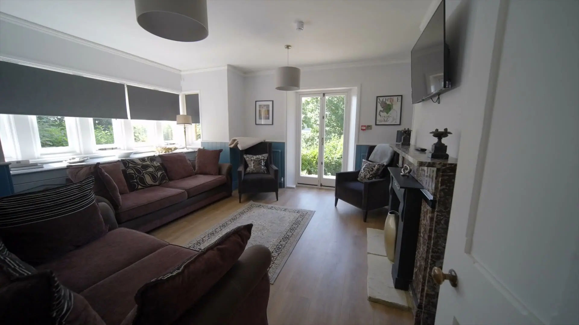 Lounge with sofas, fireplace and garden doors inside The Gatehouse at Salomons Estate