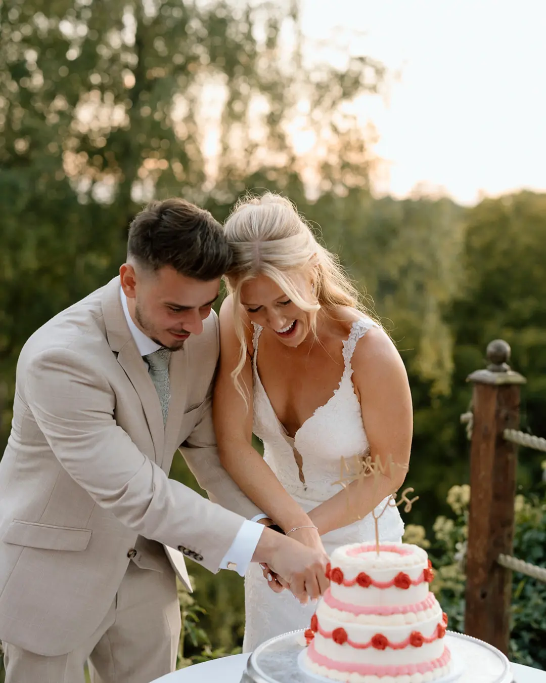 Bride and groom cutting their wedding cake in the gardens at Salomons Estate