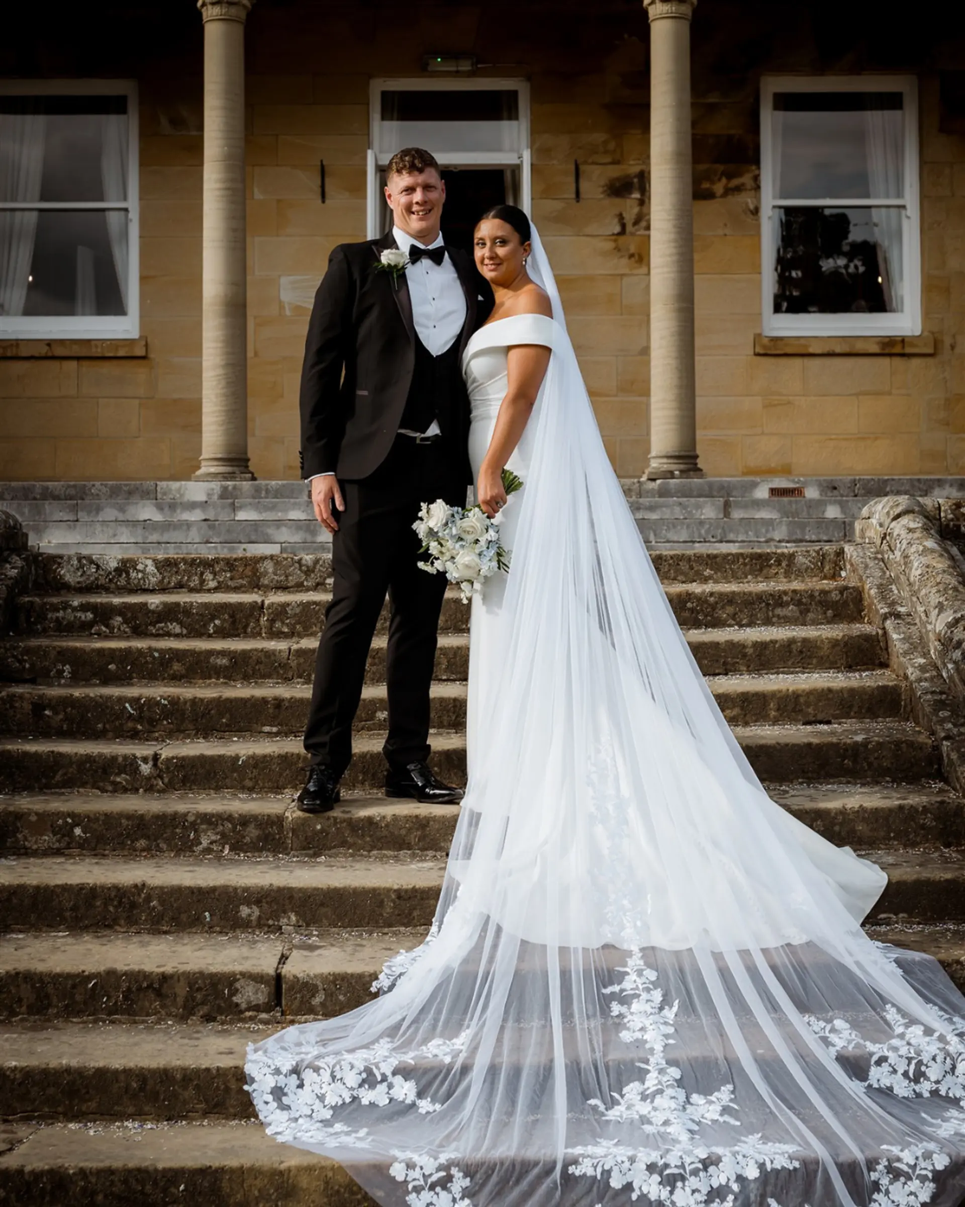 Bride and groom on the steps of the Victorian manor house at Salomons Estate