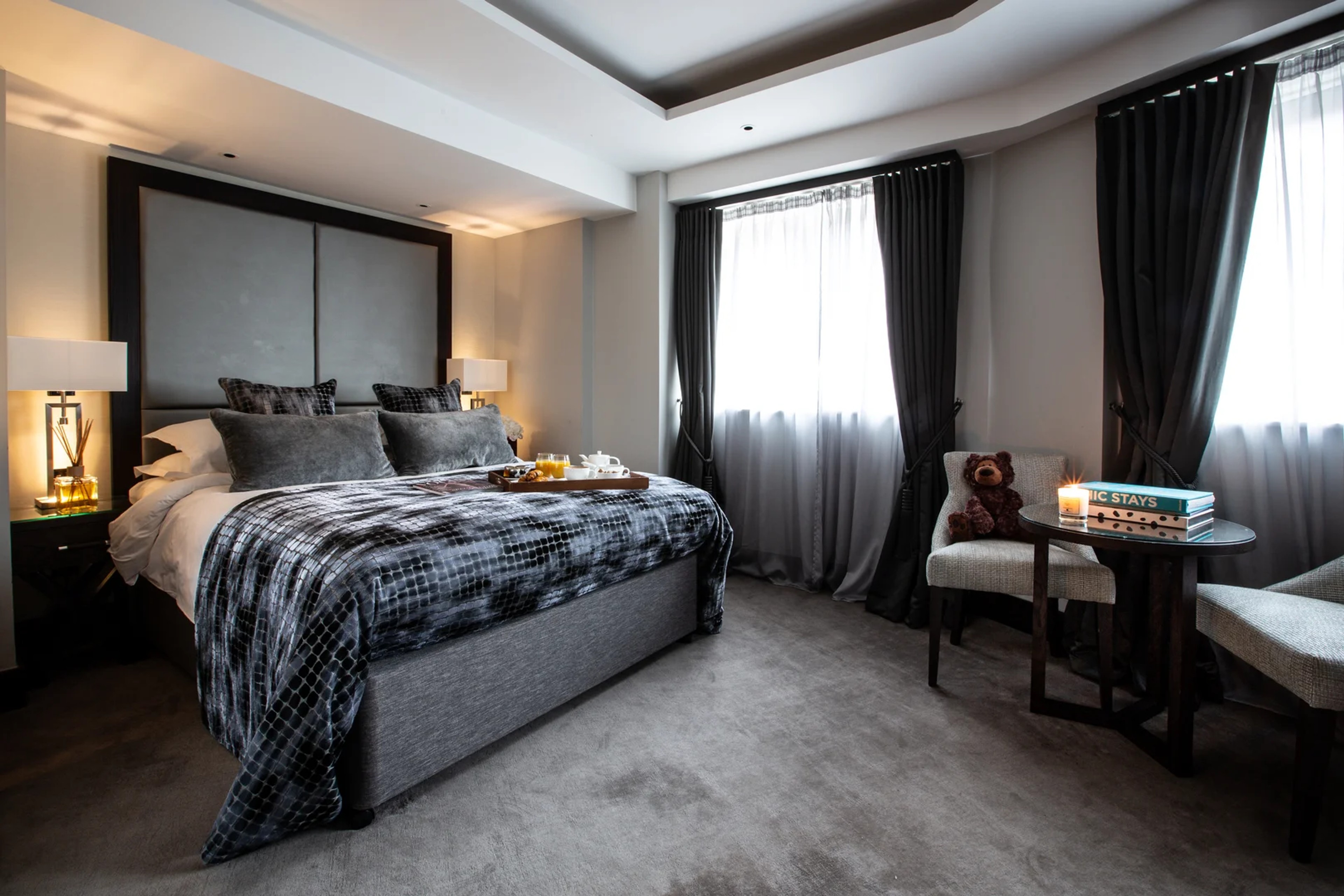 Spacious Junior Suite with king bed, grey decor and breakfast tray