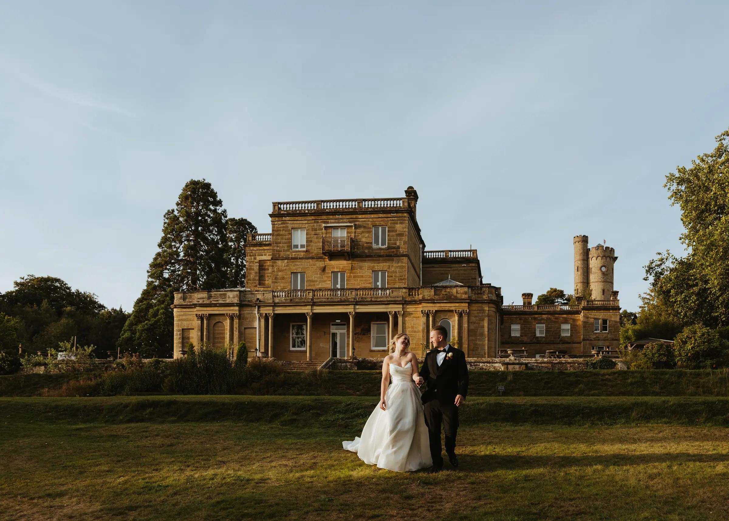 Bride and groom on the lawn in front of Salomons Estate at golden hour