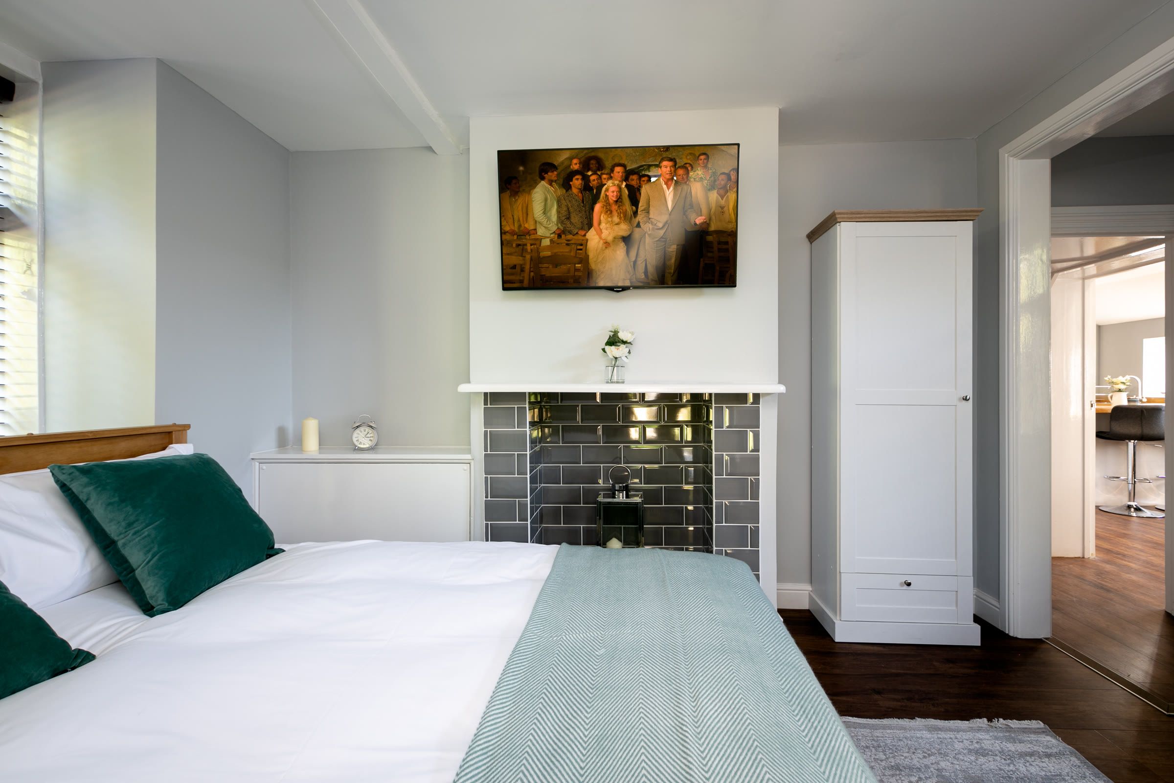 Double bedroom with a tiled fireplace and wooden bed frame at The Cottage, Salomons Estate