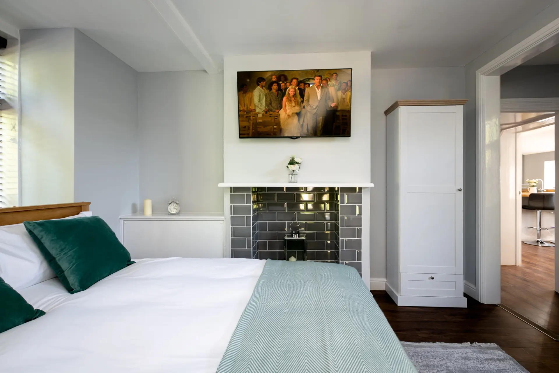 Double bedroom with a tiled fireplace and wooden bed frame at The Cottage, Salomons Estate
