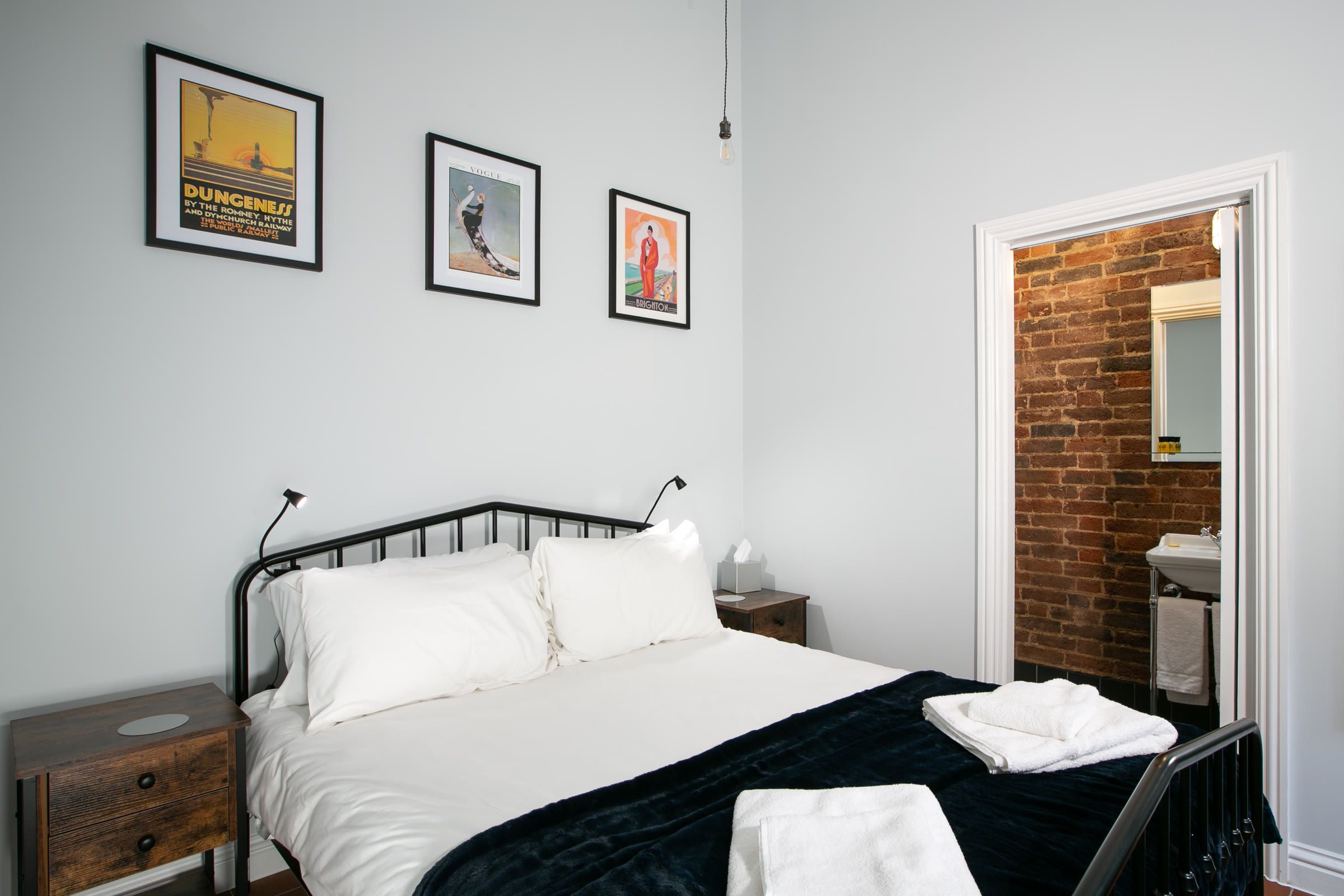 Double bedroom with framed prints and an en-suite doorway in a Garden Cottage at Salomons Estate