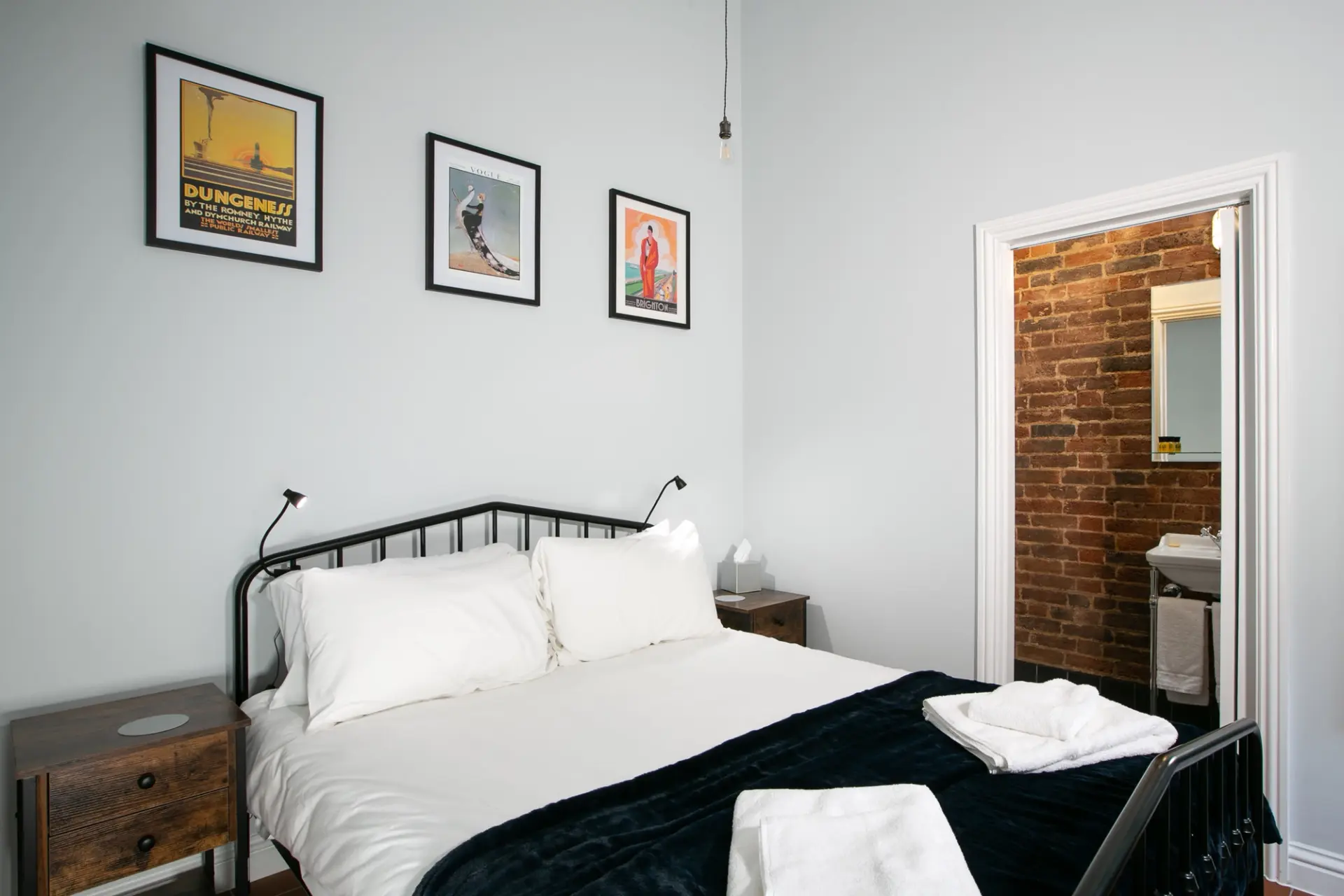 Double bedroom with framed prints and an en-suite doorway in a Garden Cottage at Salomons Estate