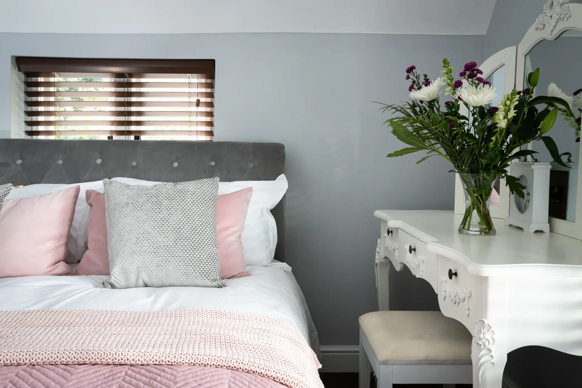 Double bedroom with an upholstered headboard and dressing table at The Cottage, Salomons Estate