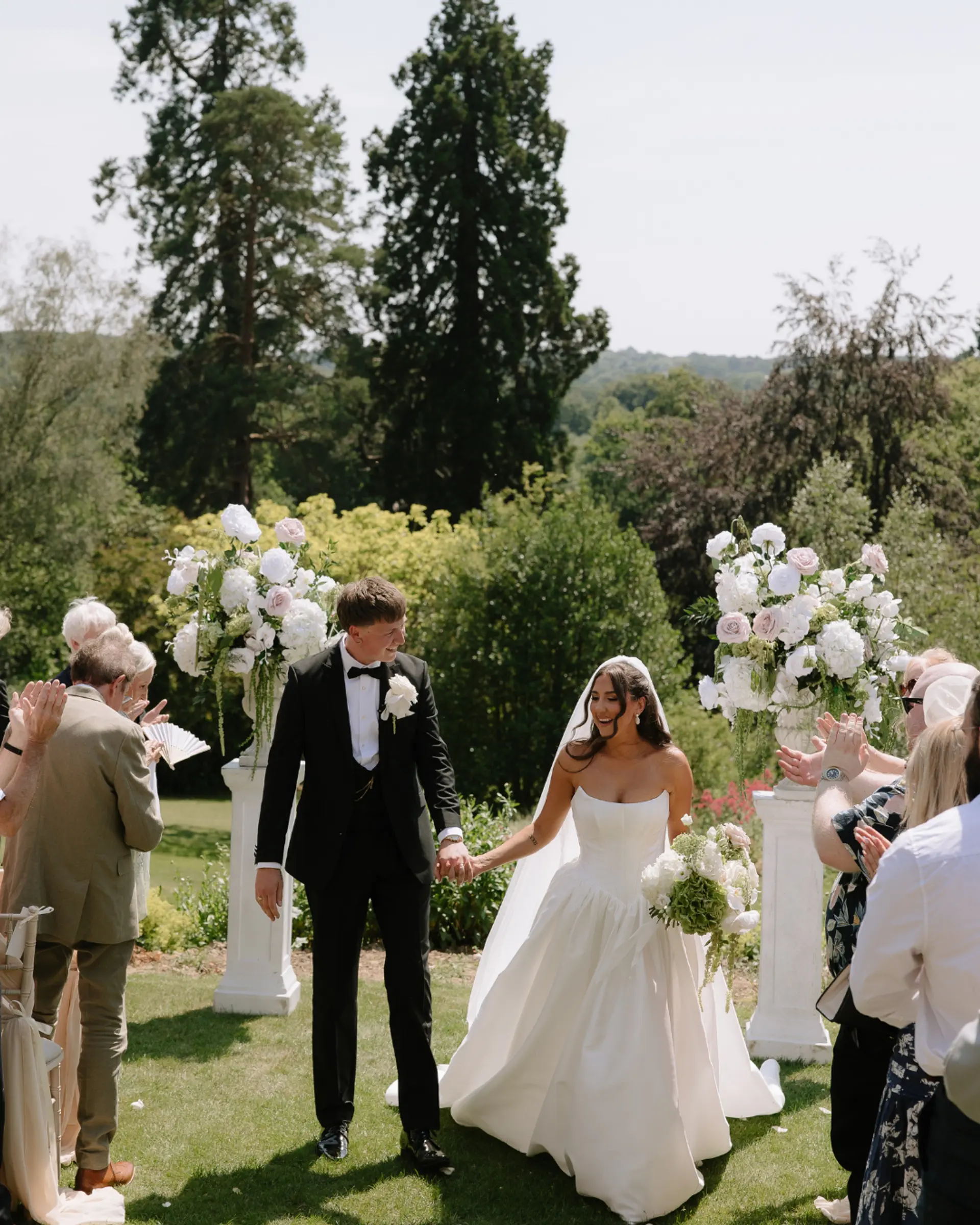 Newly married couple leaving an outdoor ceremony at Salomons Estate