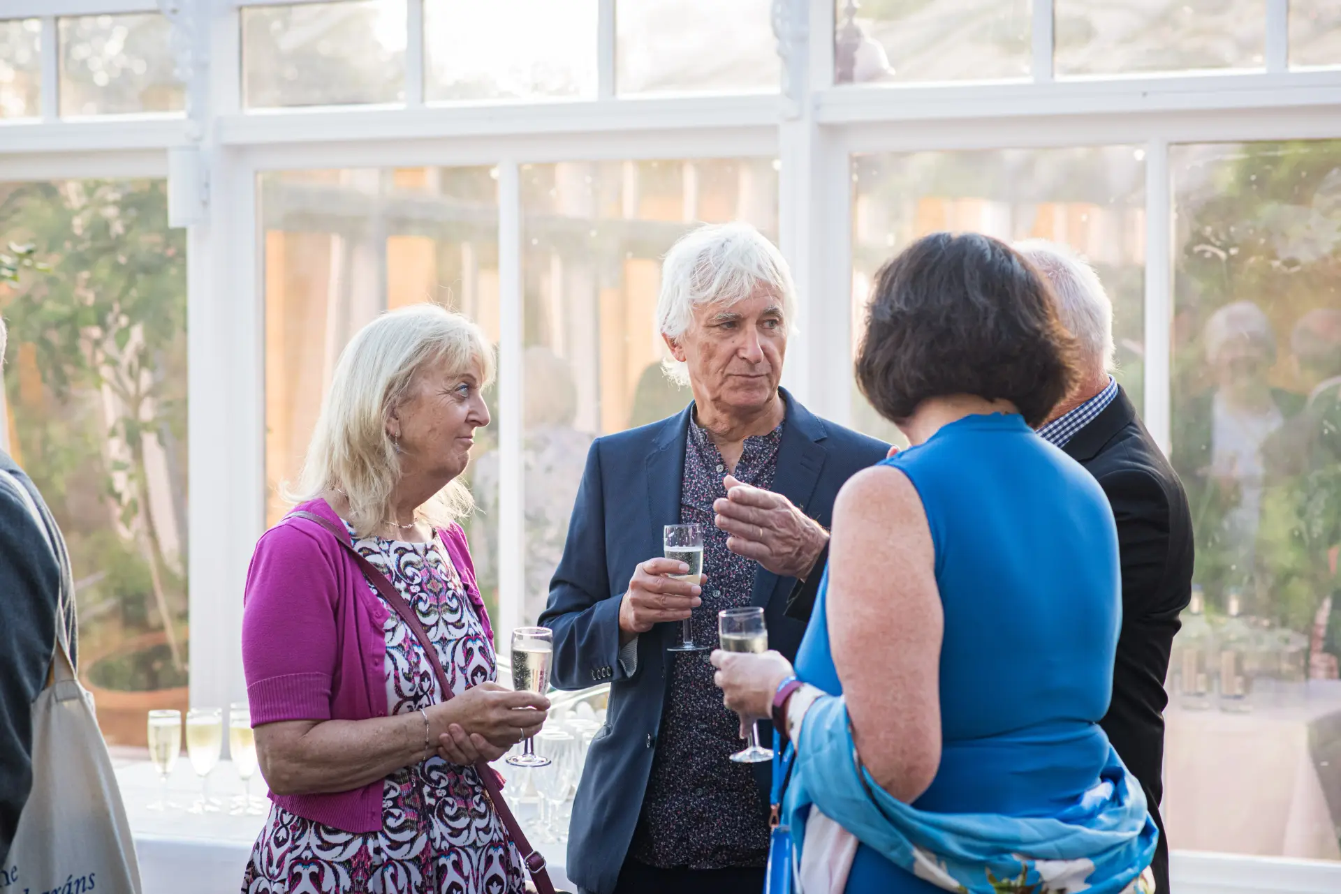Guests networking with drinks at a corporate event in the Conservatory at Salomons Estate