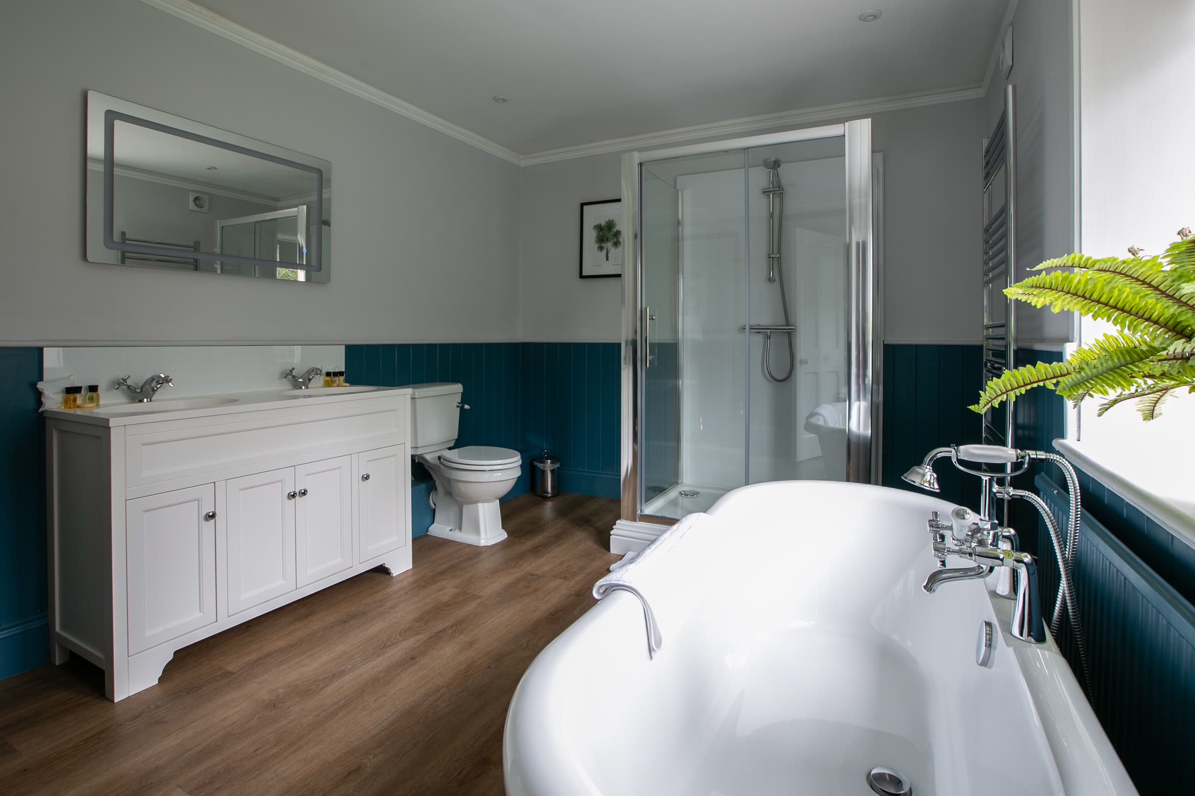 Family bathroom with a roll top bath, walk-in shower and twin basins in The Gatehouse at Salomons Estate