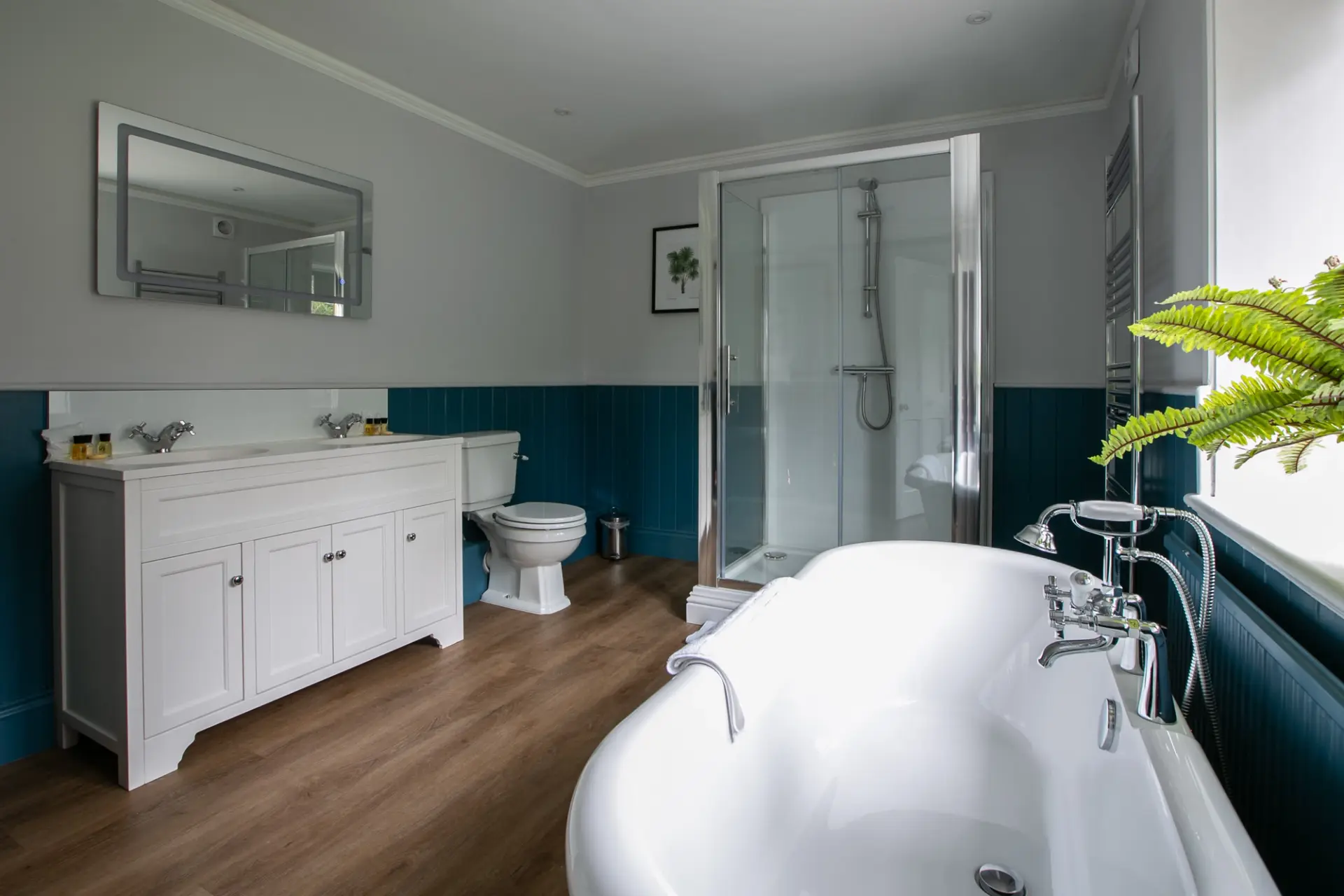 Family bathroom with a roll top bath, walk-in shower and twin basins in The Gatehouse at Salomons Estate