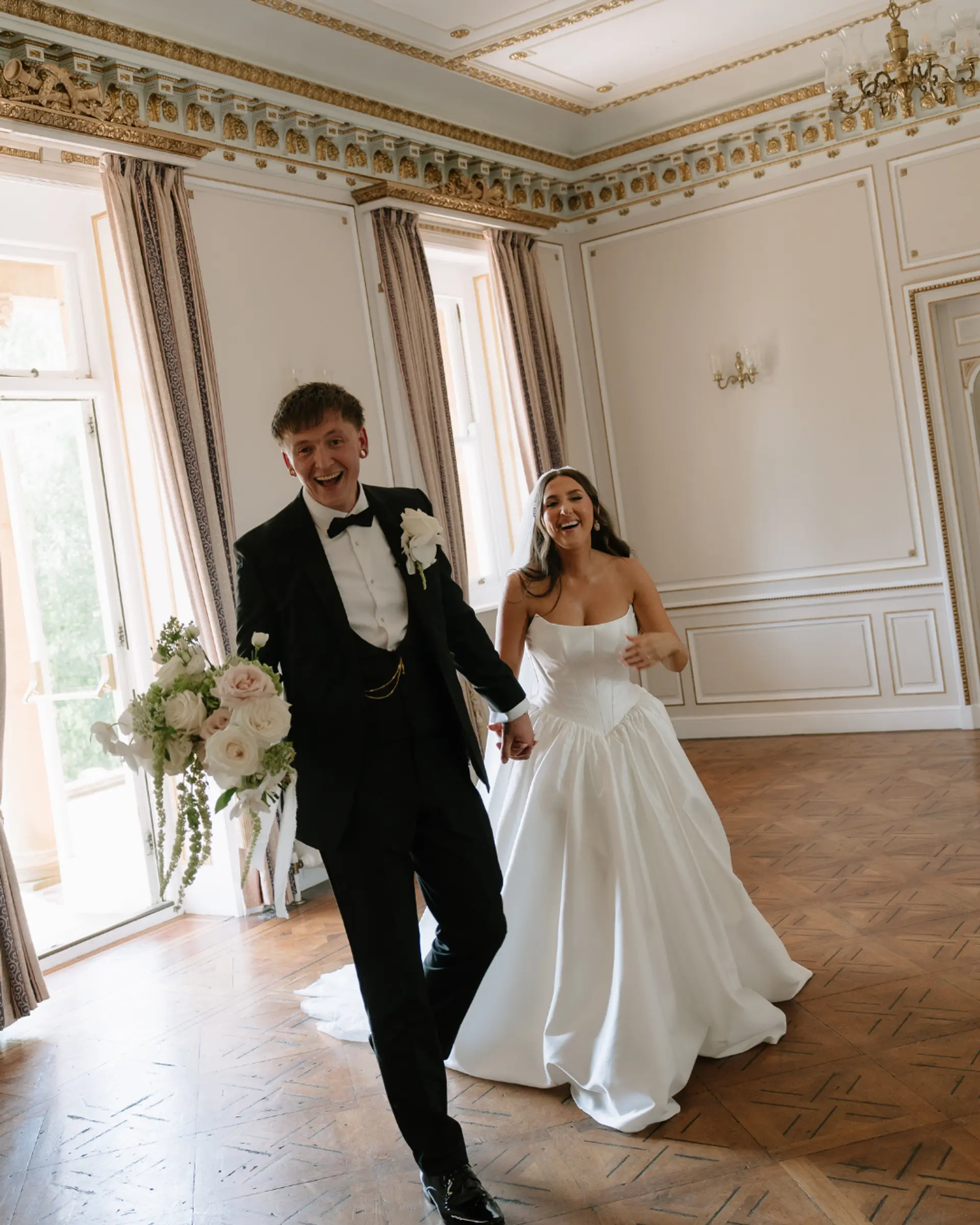 Newly married couple walking through an elegant Victorian room at Salomons Estate