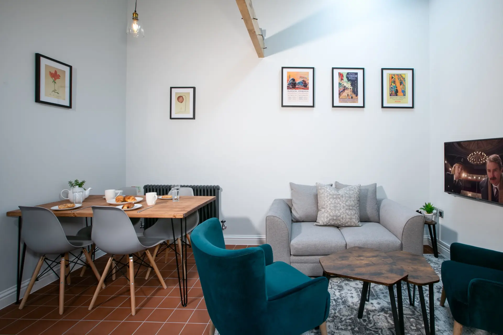 Open plan living and dining area with a sofa, armchairs and dining table in a Garden Cottage at Salomons Estate