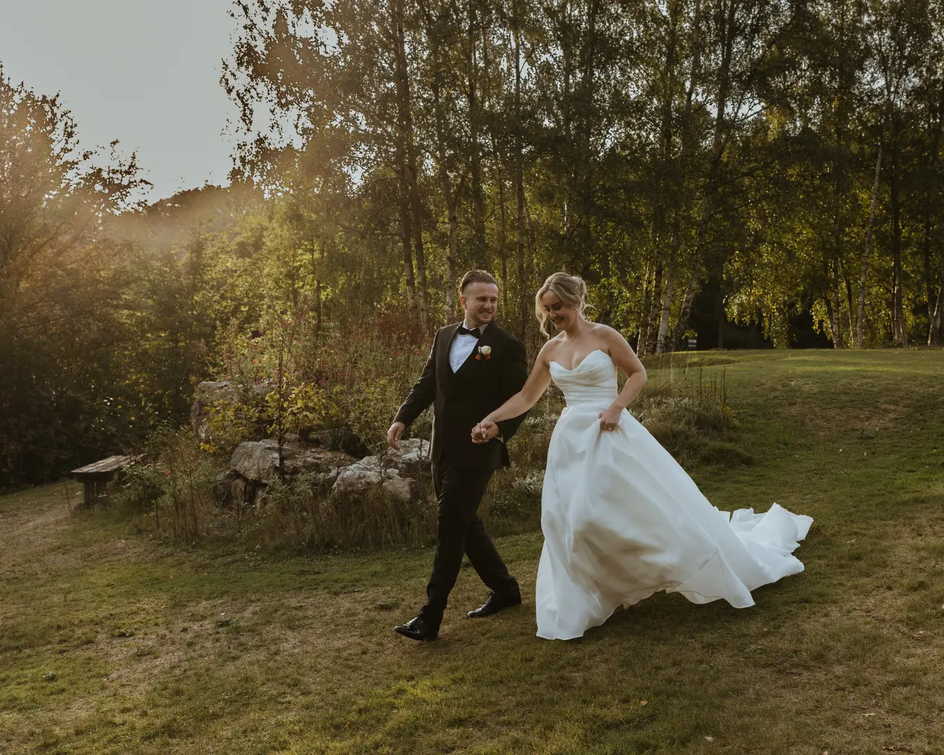Bride and groom walking through the grounds at golden hour at Salomons Estate
