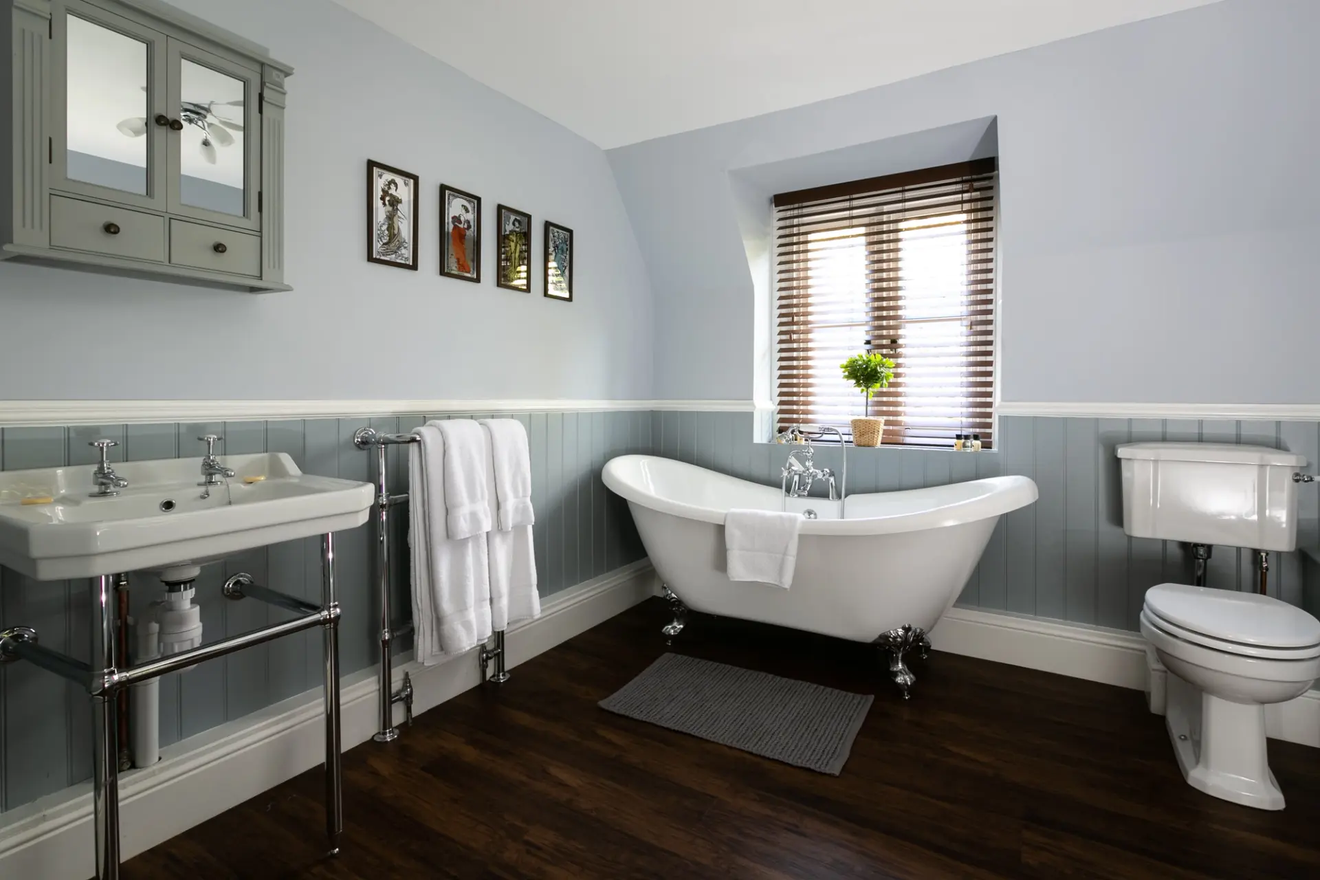 Bathroom with a roll top slipper bath and twin basins at The Cottage, Salomons Estate