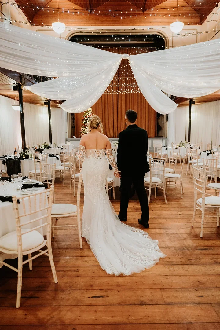 Bride and groom walking through the Theatre at Salomons Estate with fairy lights overhead