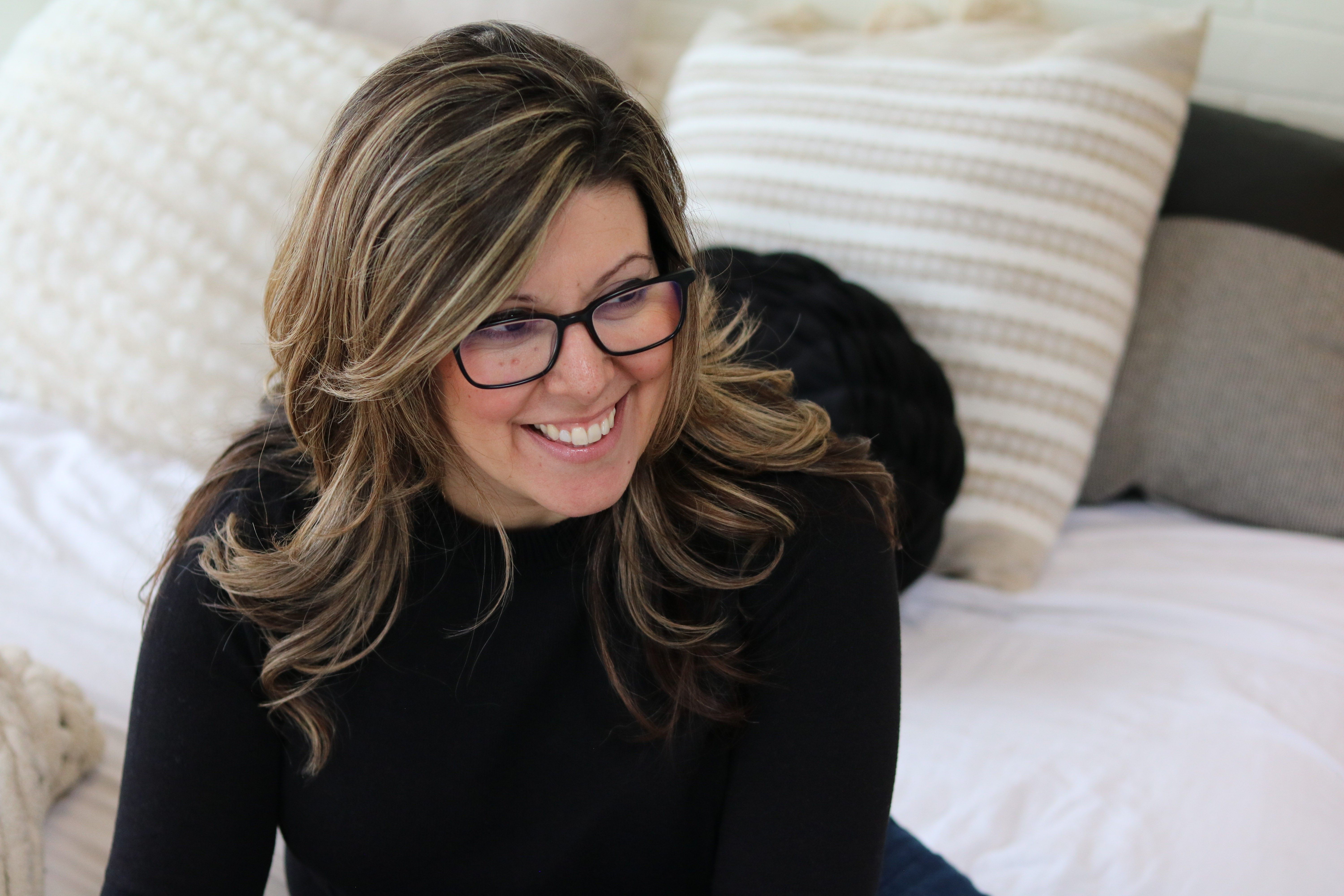 Stephanie is sitting, working, in conversation with people talking about business and mindset