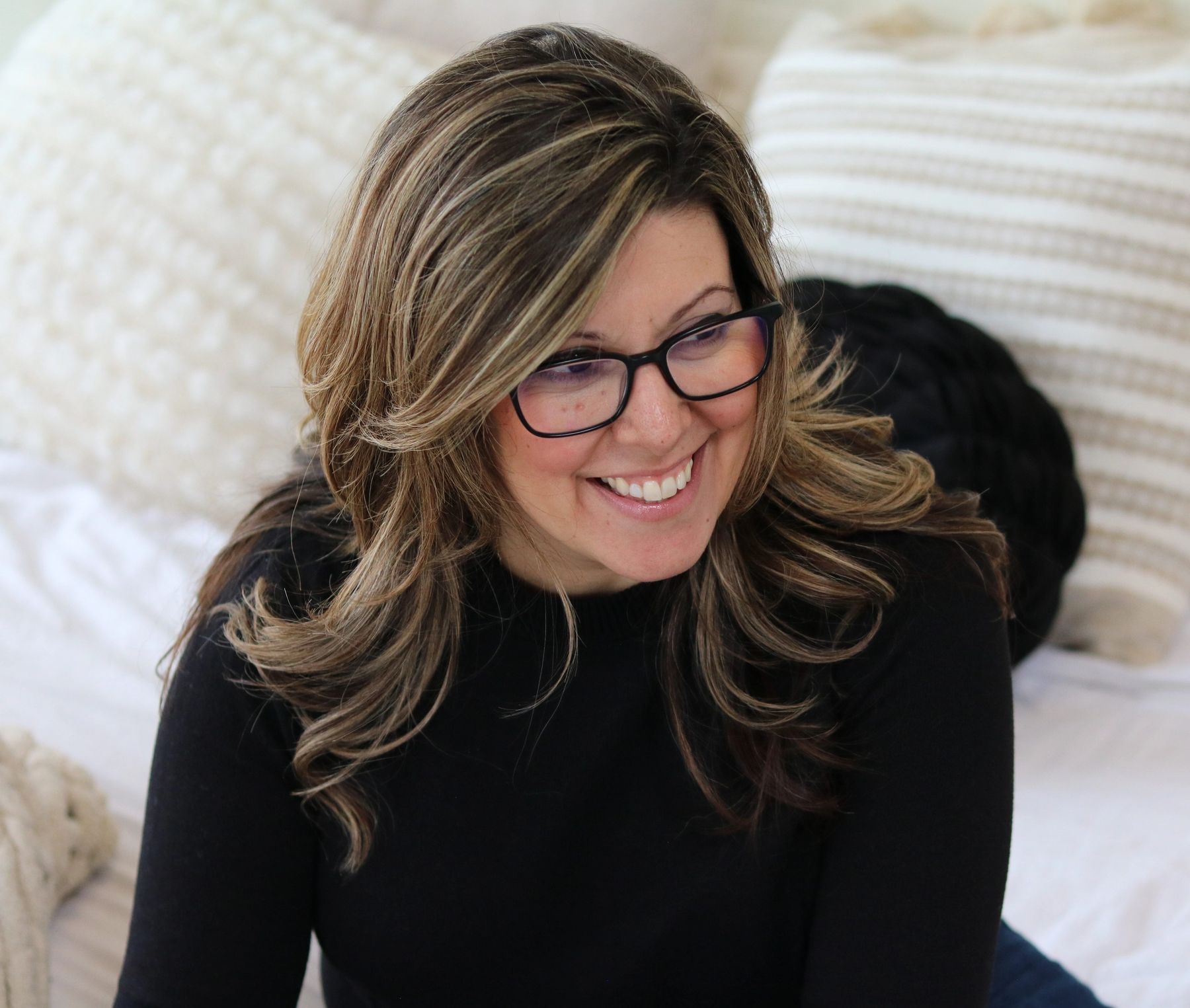 Stephanie is sitting, working, in conversation with people talking about business and mindset