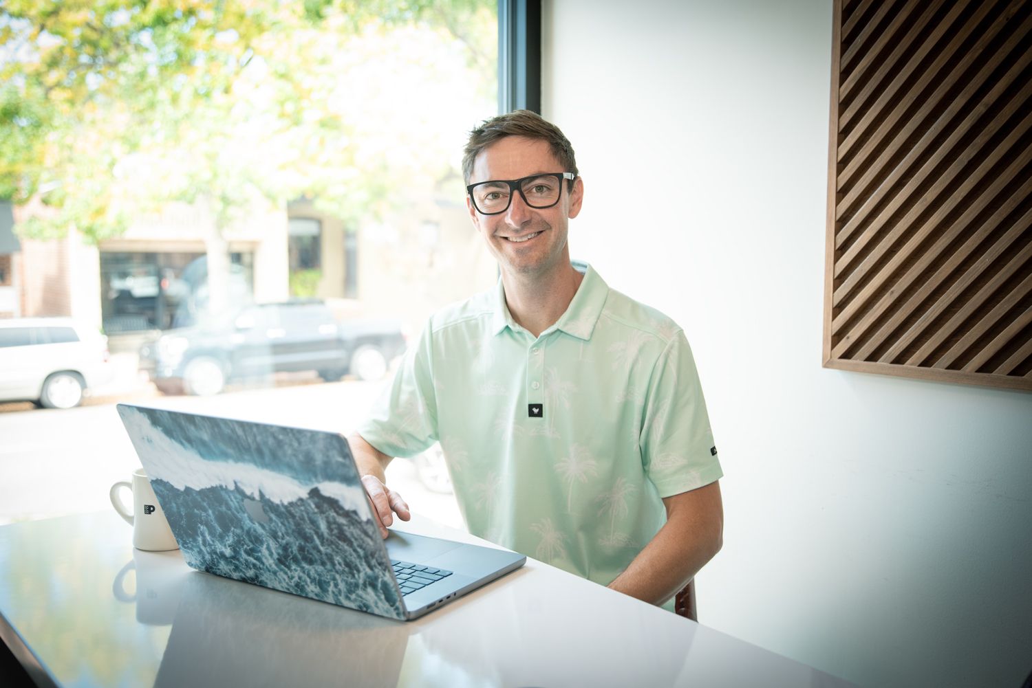 Connor Walberg sitting with laptop and working on SEO for a photographers site
