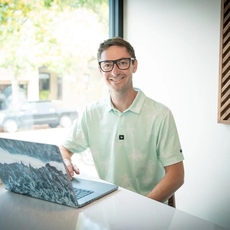 Connor Walberg sitting with laptop and working on SEO for a photographers site