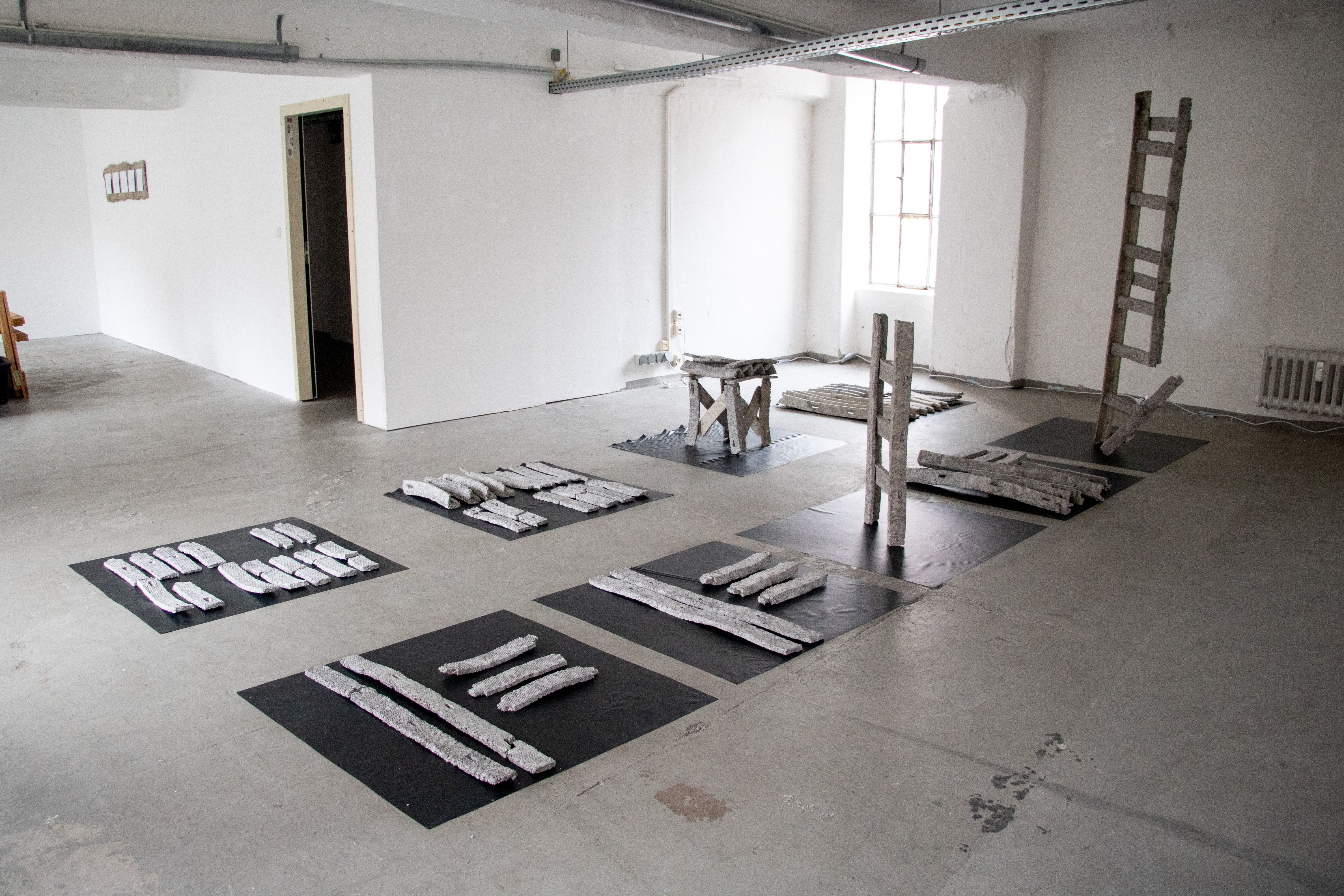 Dorothee Brübach, Grauarbeiten: Sichtung, 2022, Pappmaché-Objekte, Pappmaché-Module, Teichfolie, Maße variabel