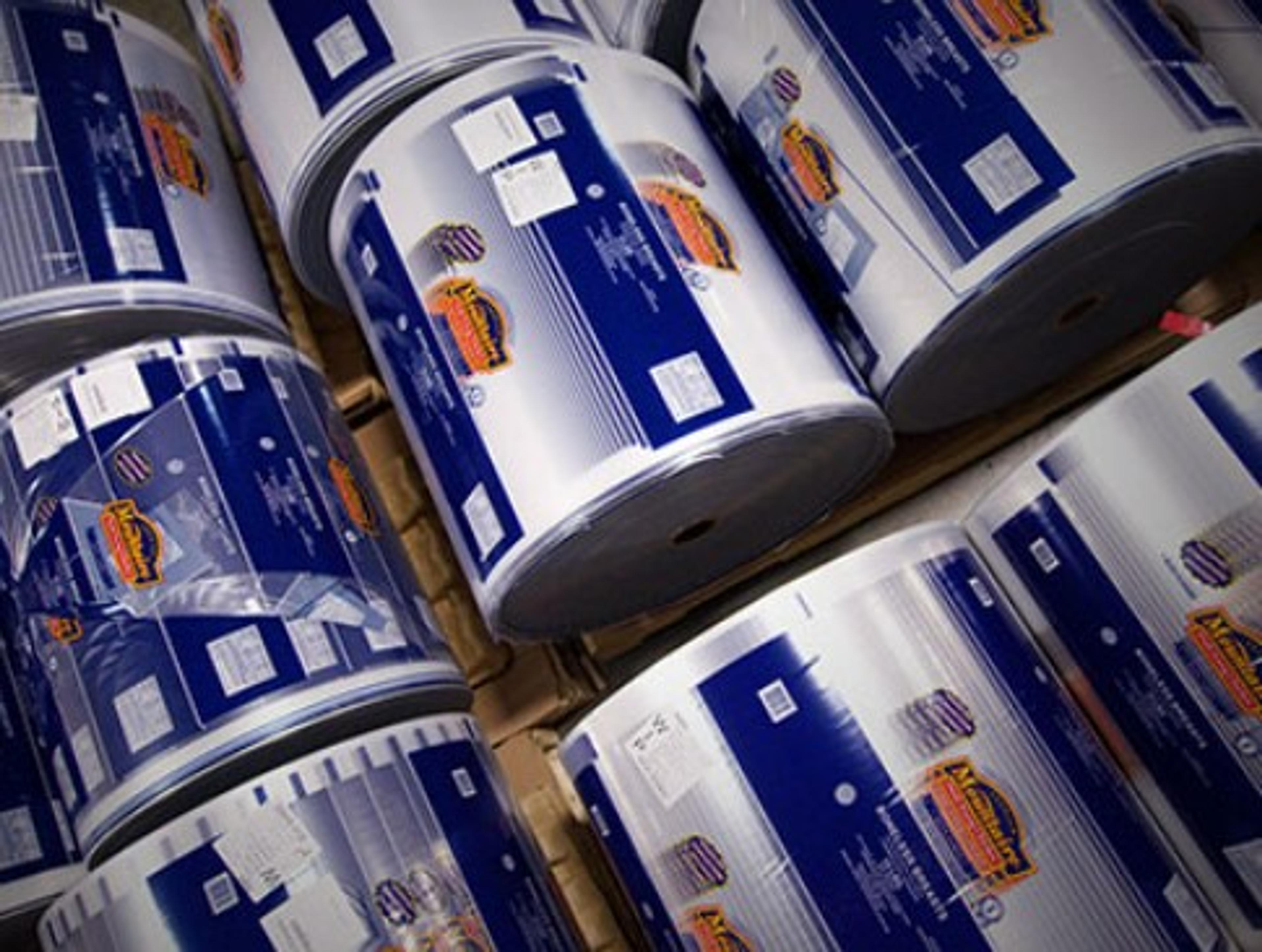 Stacked printed flexible film rolls with blue-and-white labels on pallets, overhead view