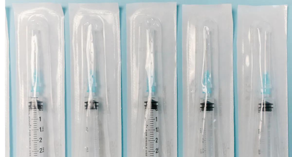 Sterile syringes in blister pouches Five sterile syringes individually sealed in clear medical blister pouches on a light blue background