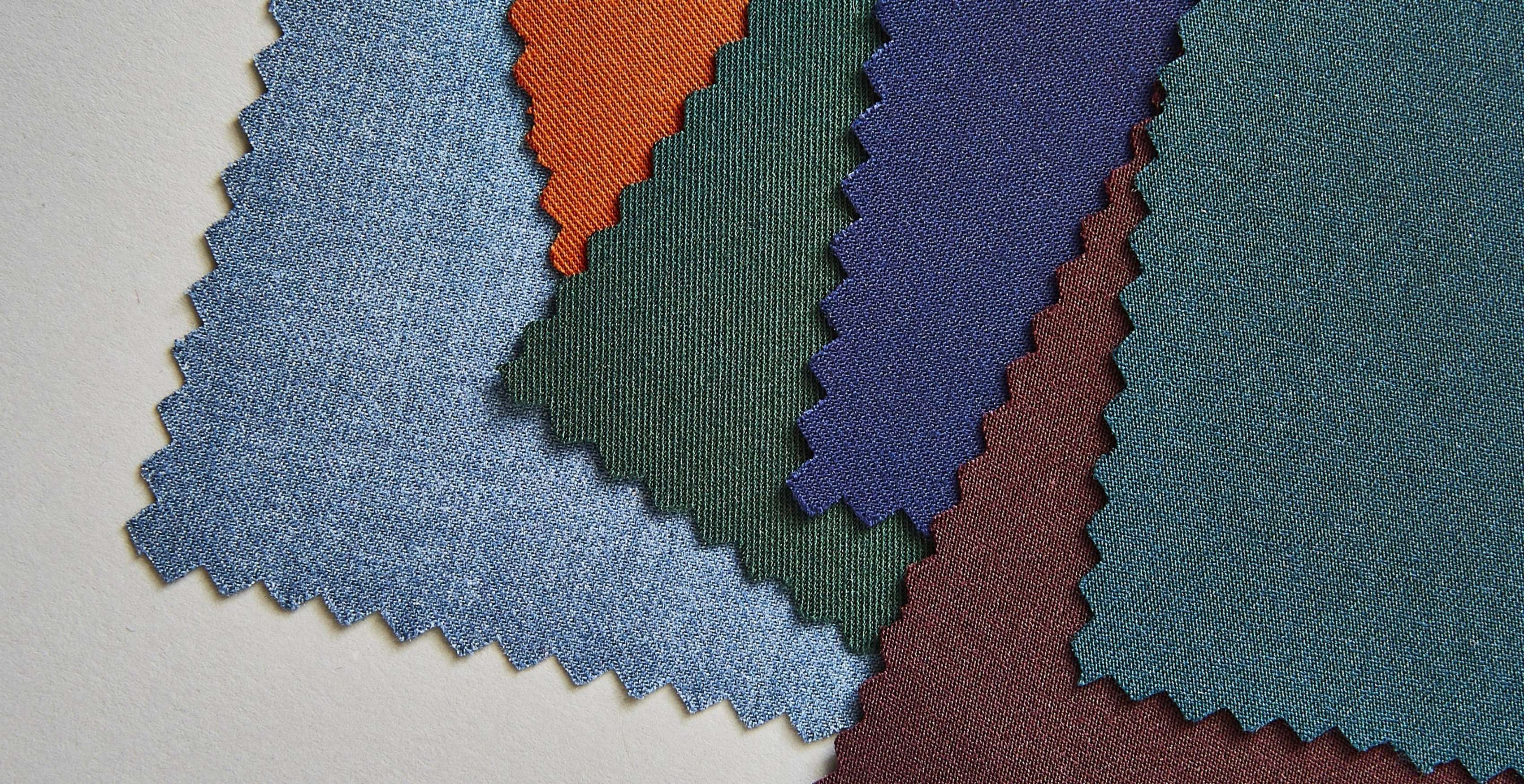 A selection of swatch colors on a table, including light blue, dark green, brilliant blue suit swatches