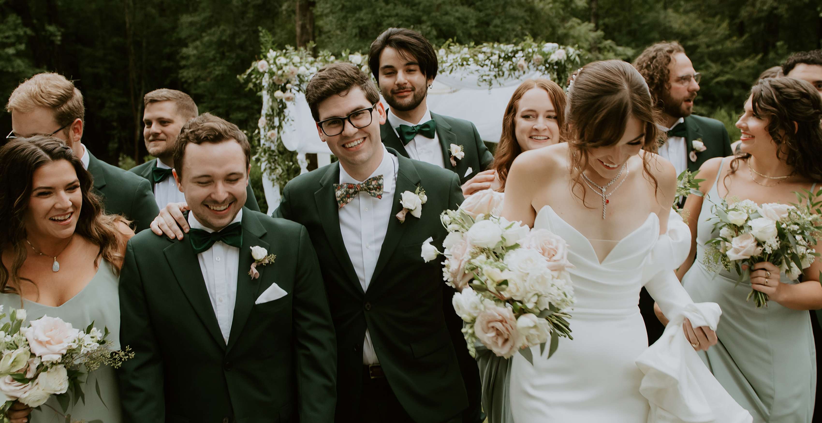 Happy wedding party in olive green suits and sage dresses