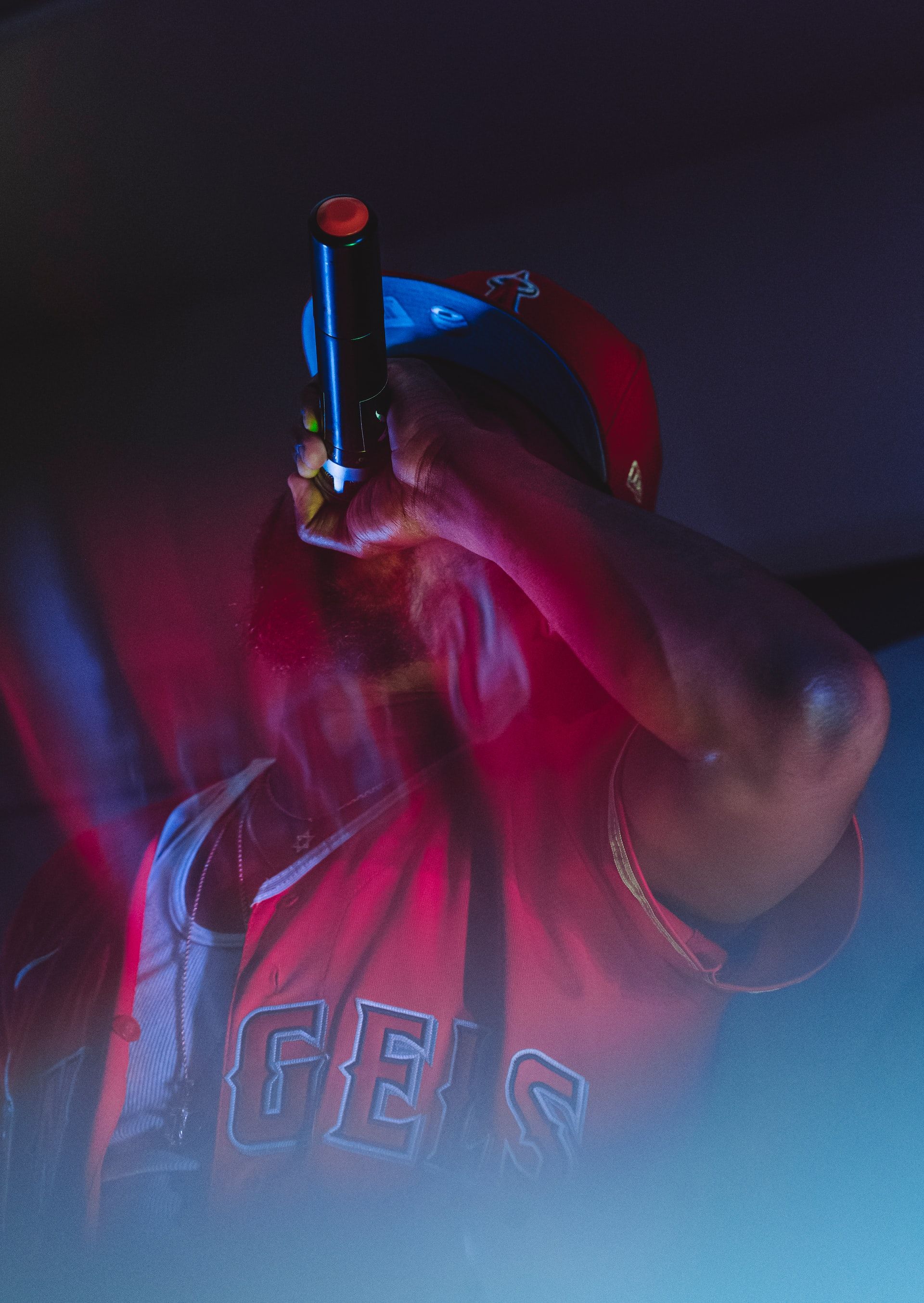 A picture of a man in a red vest holding a microphone