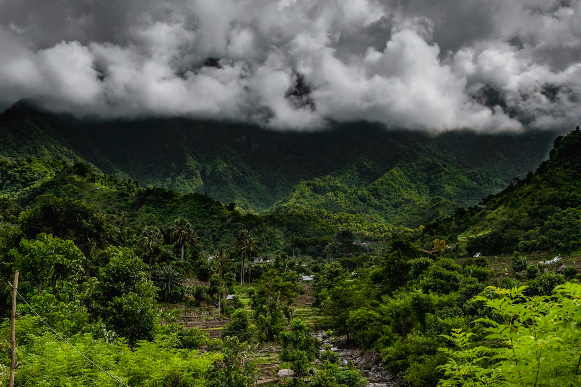 A green mountain landscape beneath cloud cover