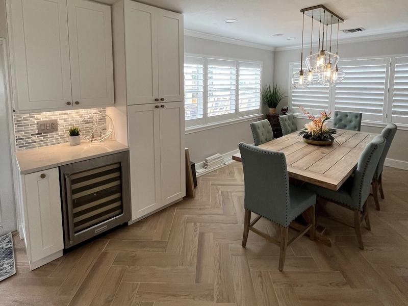Dining area with custom cabinetry and built-in wine cooler from a Deerfield Beach, FL kitchen remodel, featuring elegant finishes and modern design.