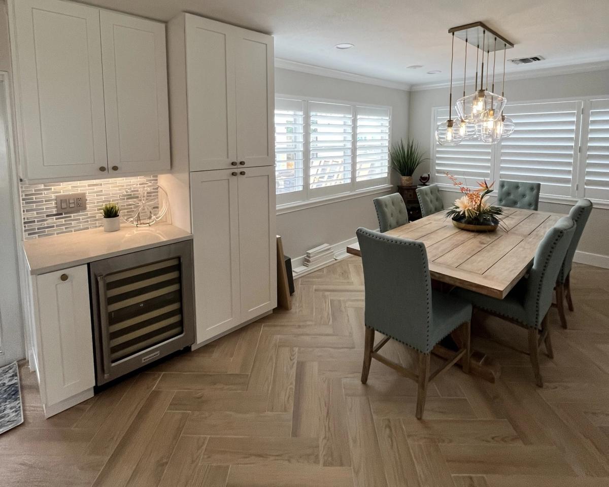 Dining area with custom cabinetry and built-in wine cooler from a Deerfield Beach, FL kitchen remodel, featuring elegant finishes and modern design.
