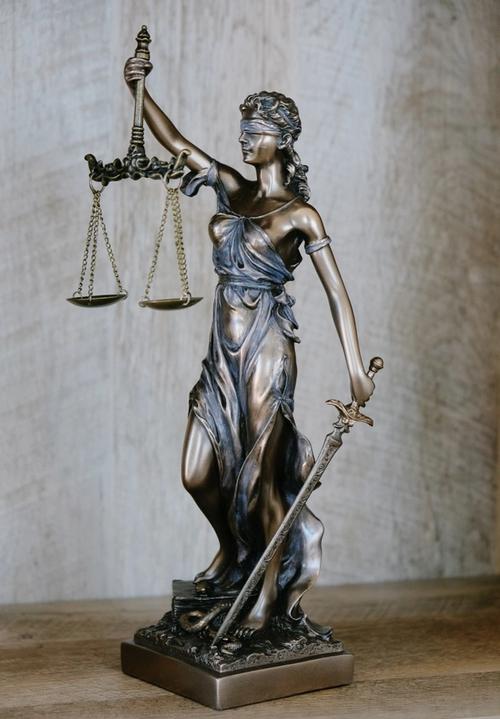 A figure of blind lady justice holding her scales and sword
