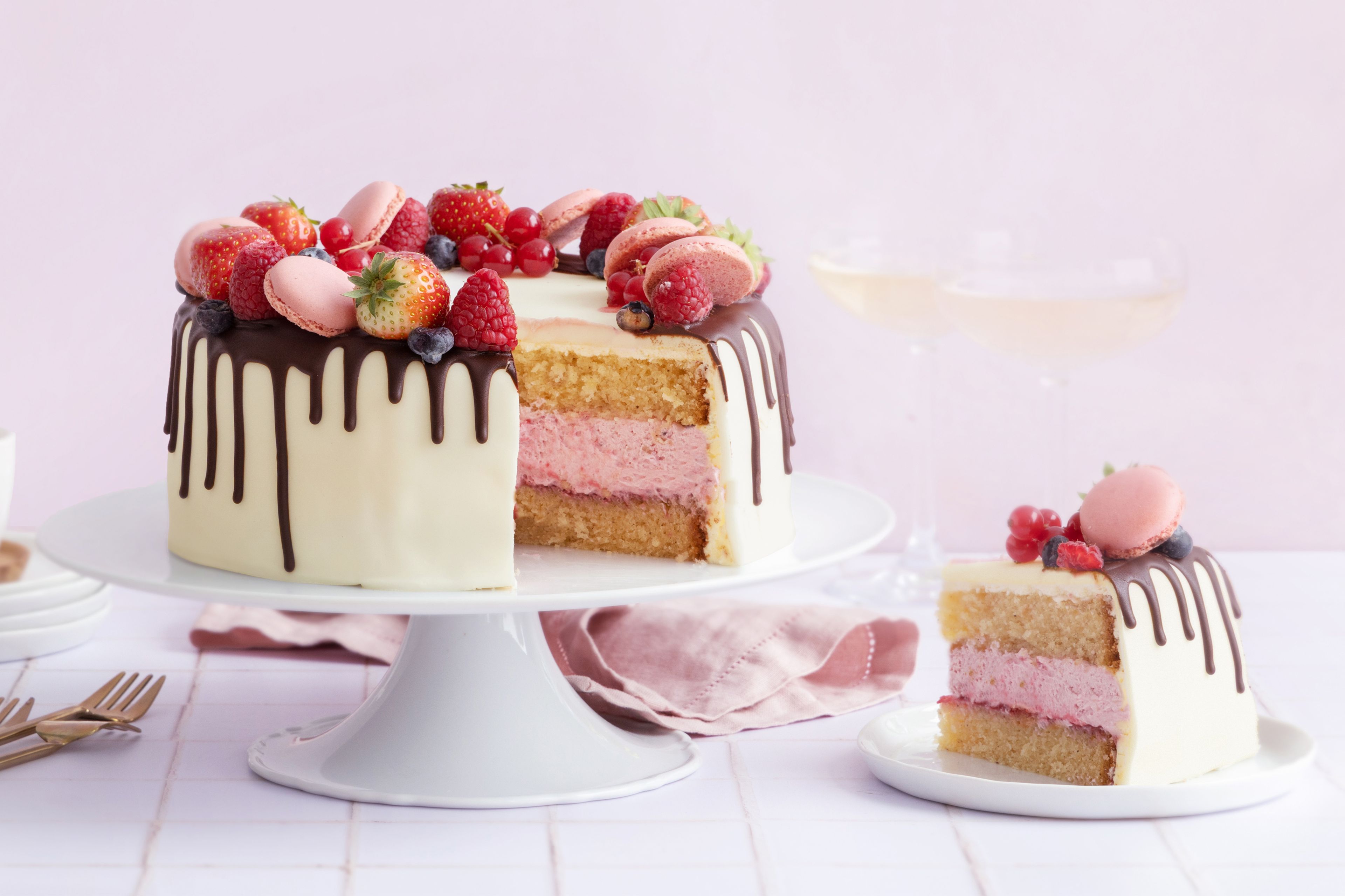 Kake pyntet med makroner, friske bær og smeltet sjokolade.